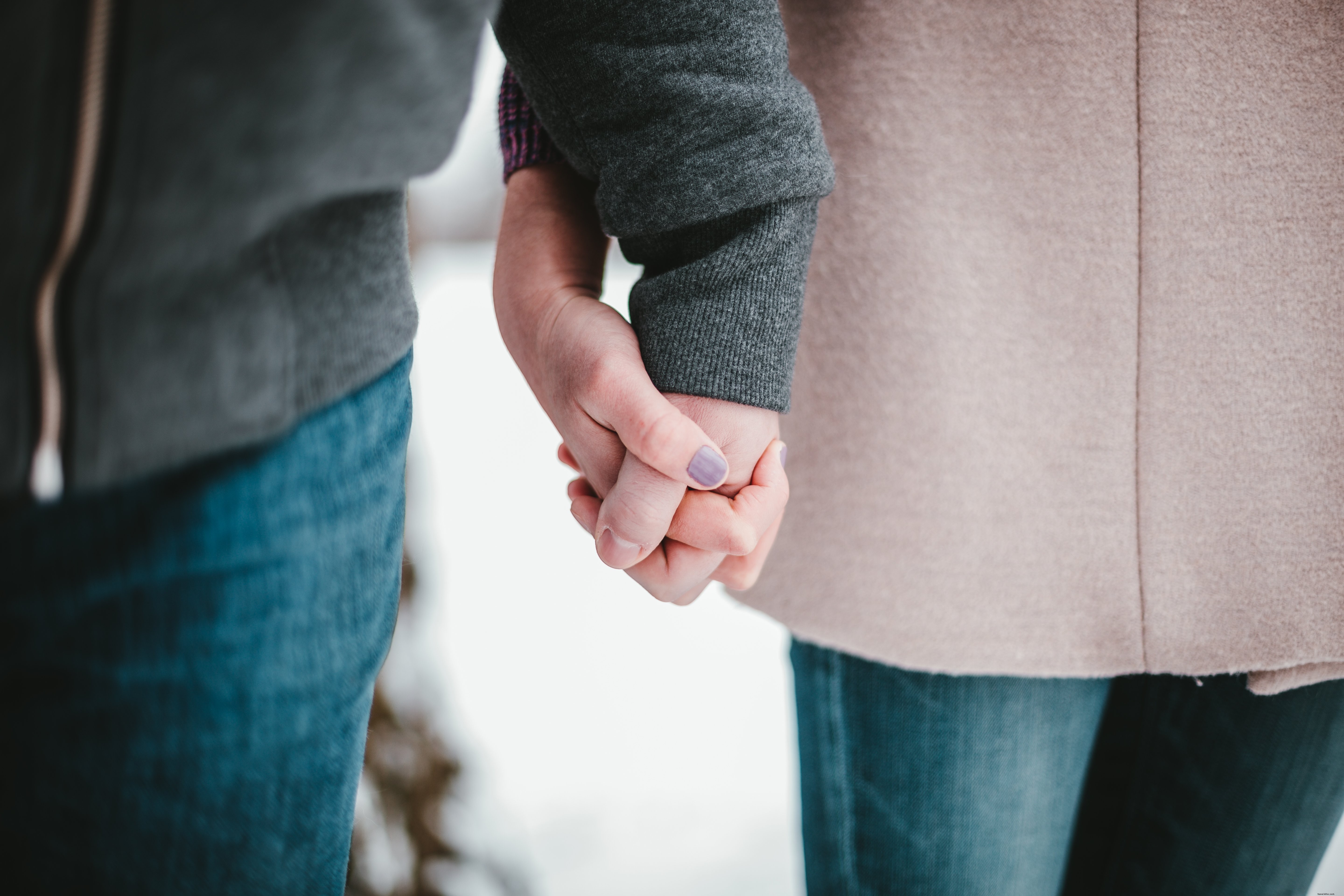 Romantic Couple Holding Hands in Snowy Winter Scene – Heartwarming Photo