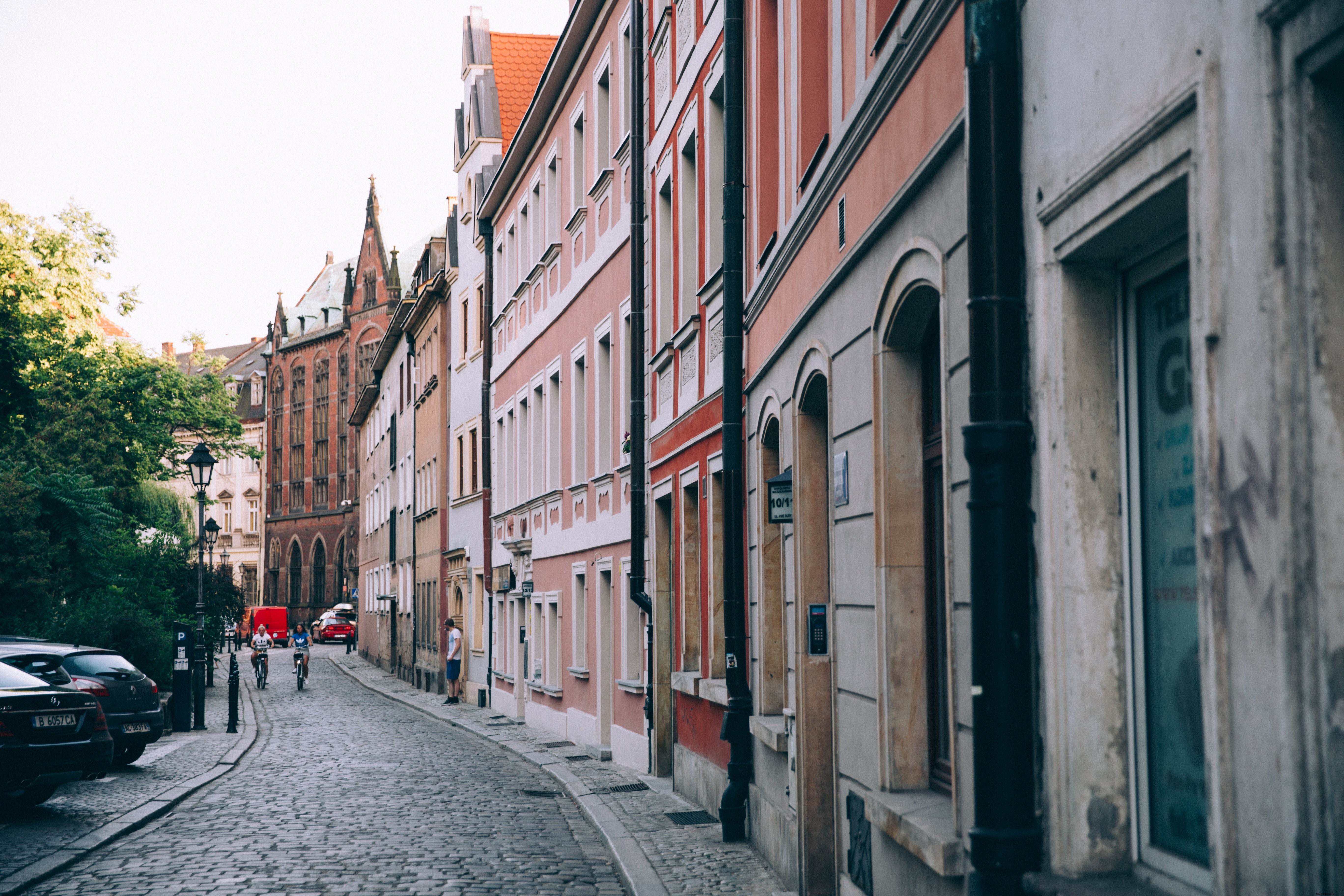 Stunning Photo: Two Cyclists Descending a Picturesque Cobbled Street