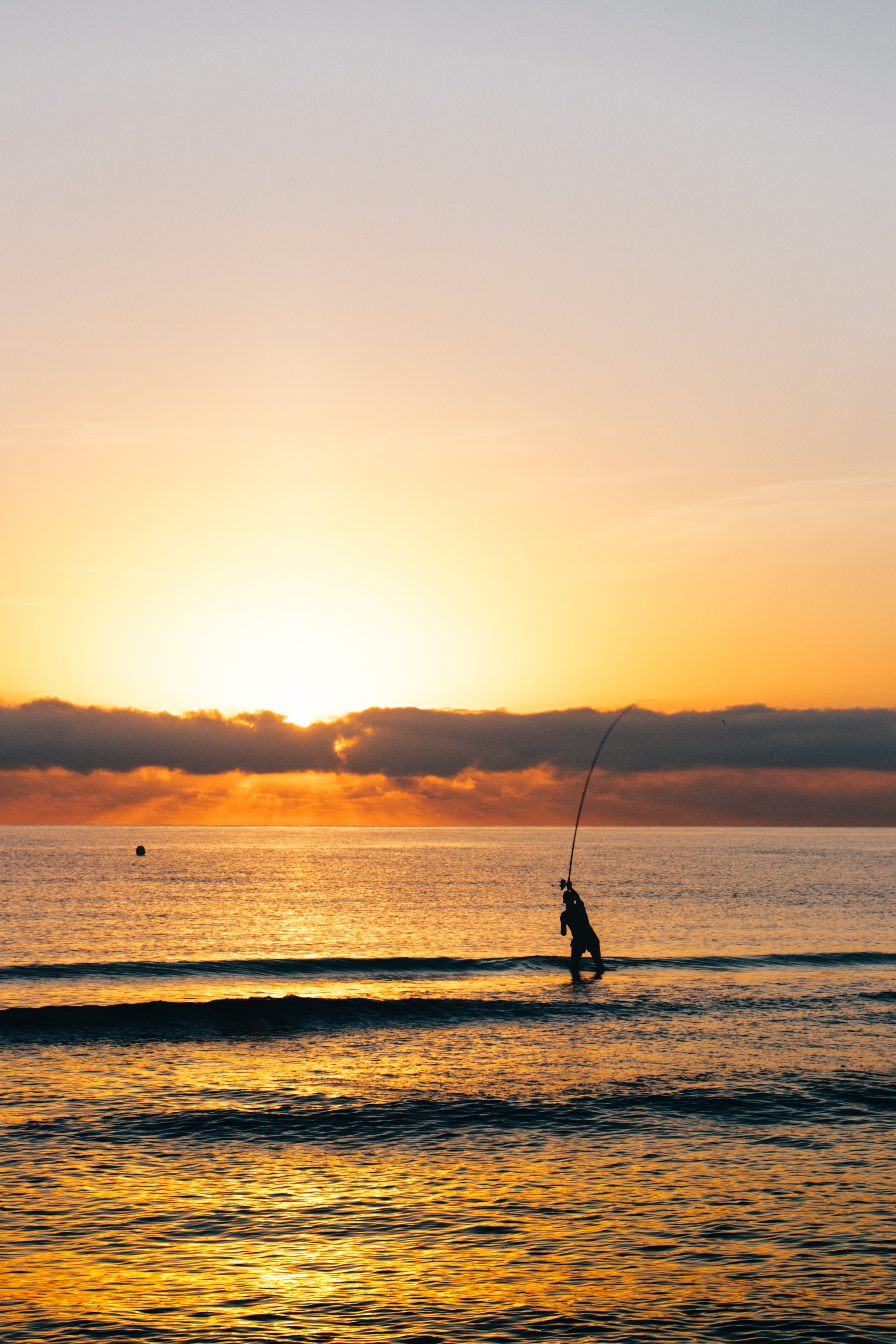 Stunning Sunrise: Fisherman Standing in Serene Waters Photo