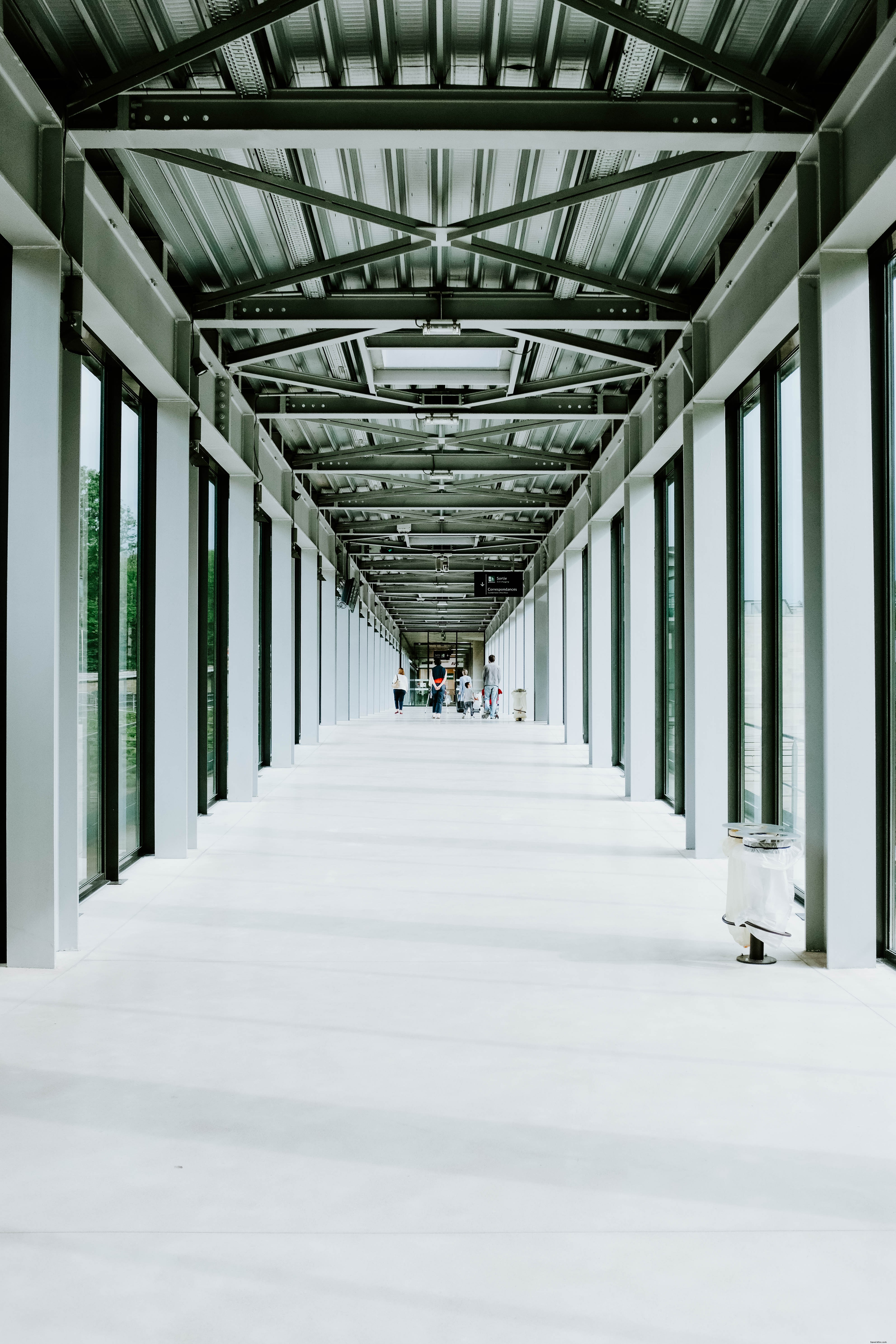 Captivating Photo: Travelers Waiting in Modern Steel-Framed Airport Terminal