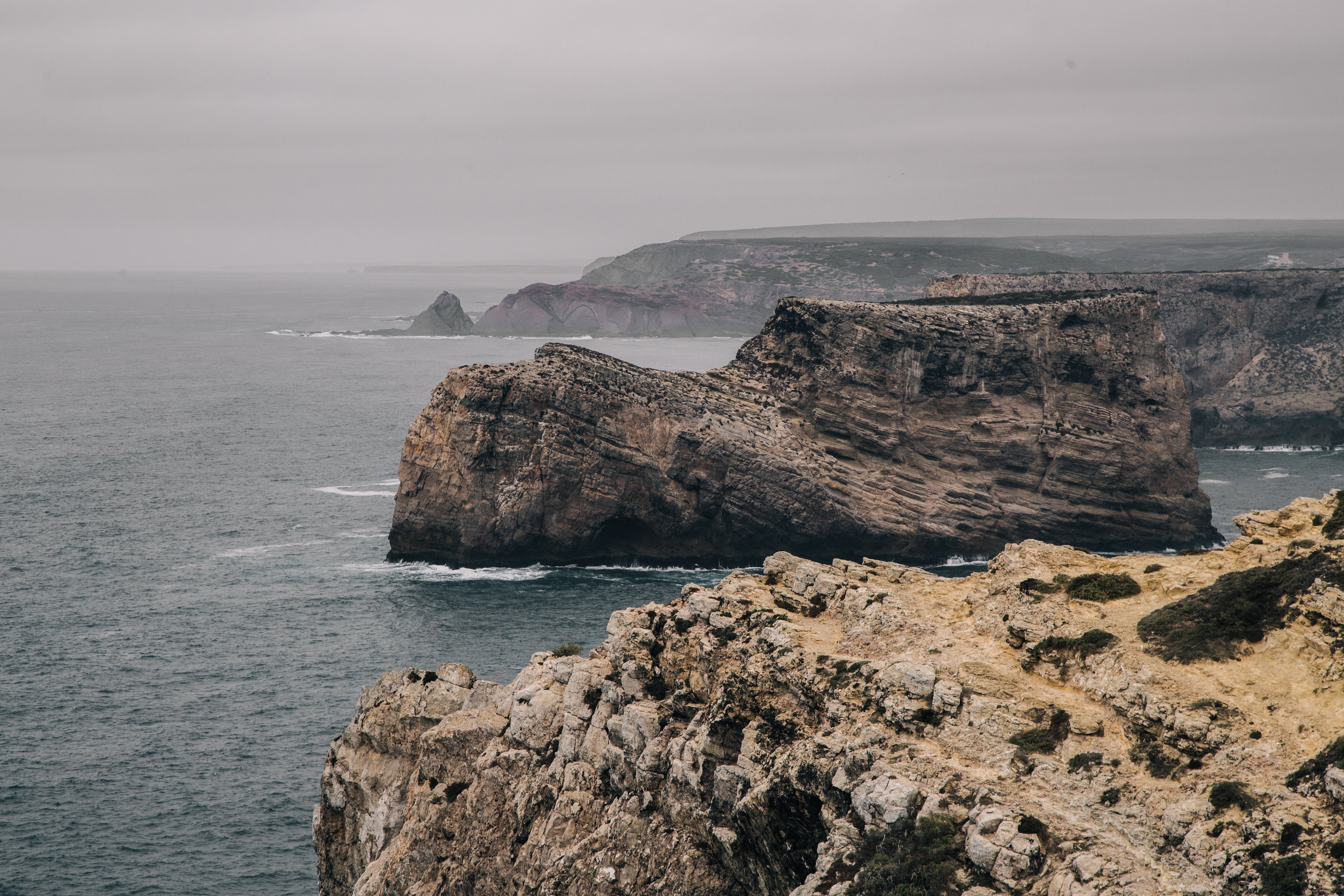 Stunning Photo: Massive Stone Outcrop Isolated Amid Grey Sea Cliffs