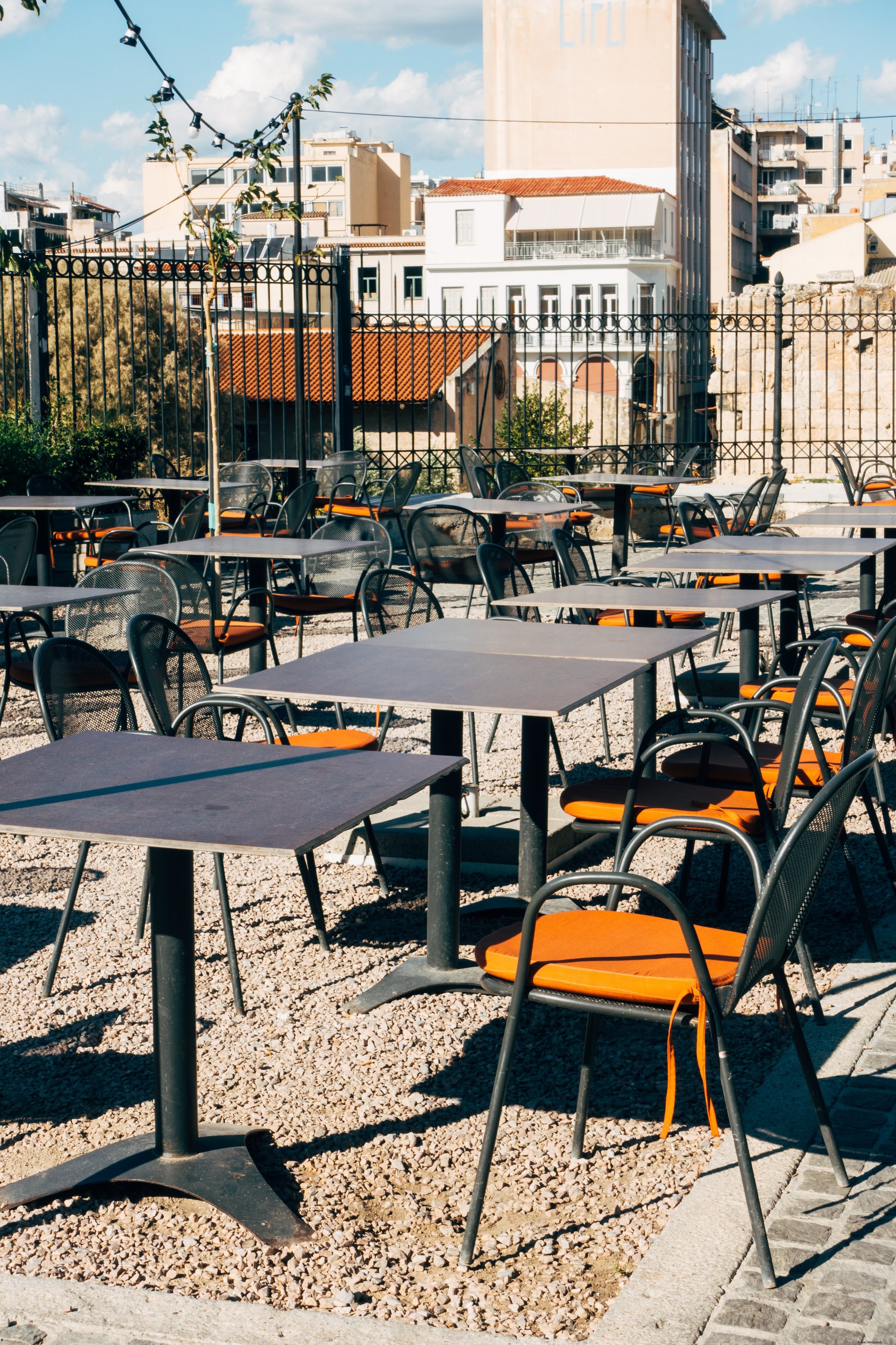 Vibrant Orange Cushions on Sleek Metal Chairs in Tranquil Empty Patio | Stunning Photo