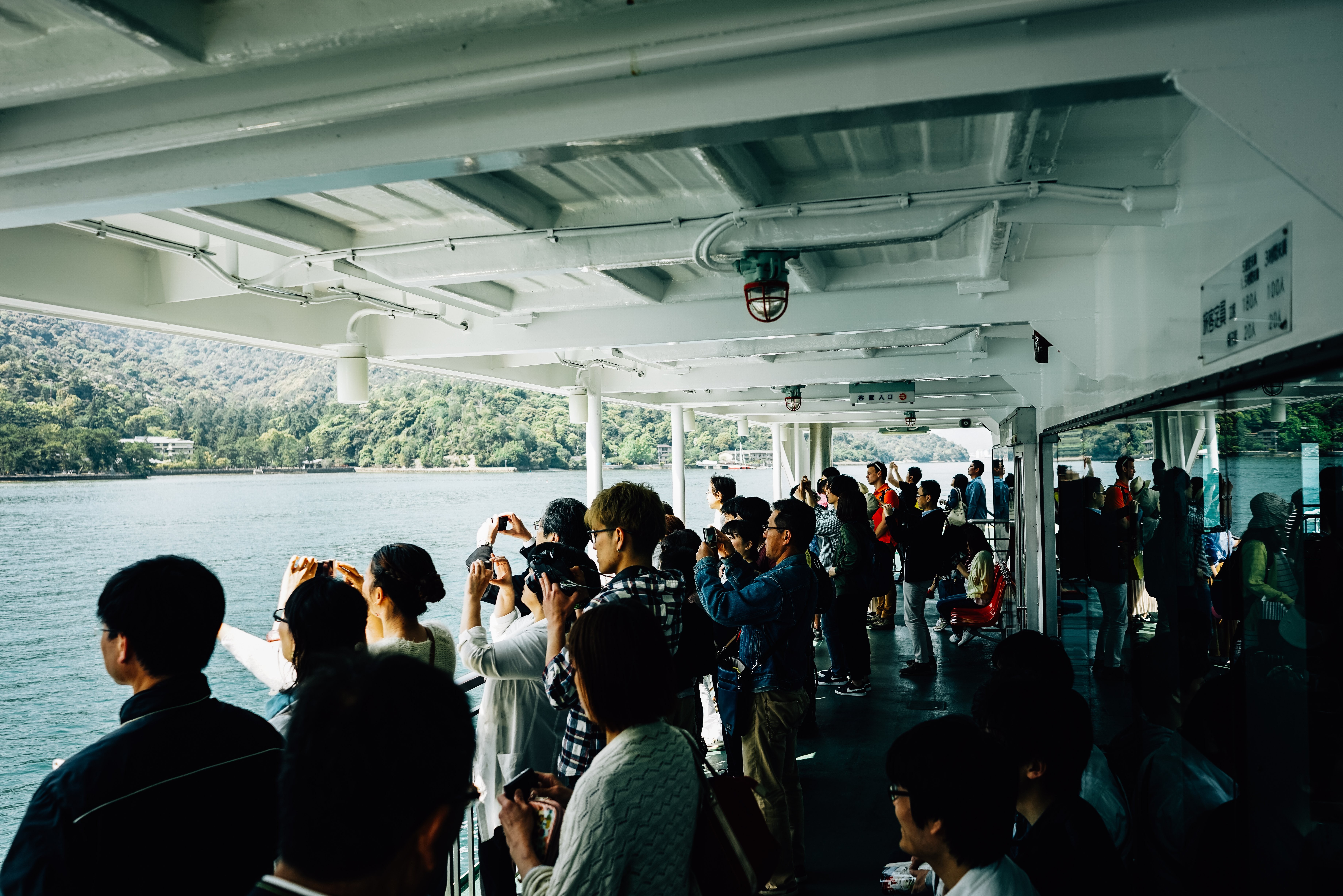 Vibrant Crowd Capturing Moments on a Scenic Boat – Stunning Photo