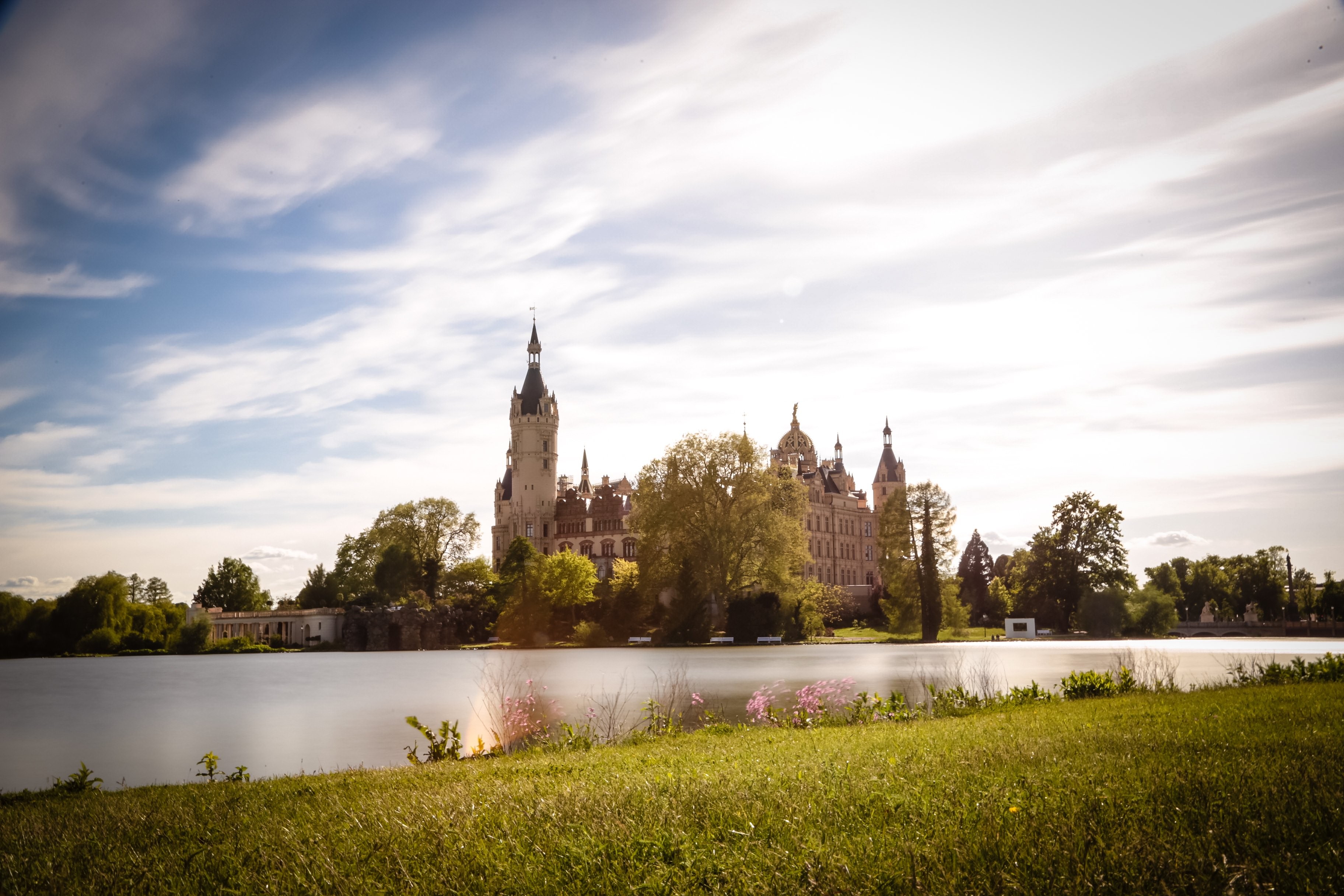Stunning Scenic Photo: Lush Green Grass by Serene Lake and Majestic Castle