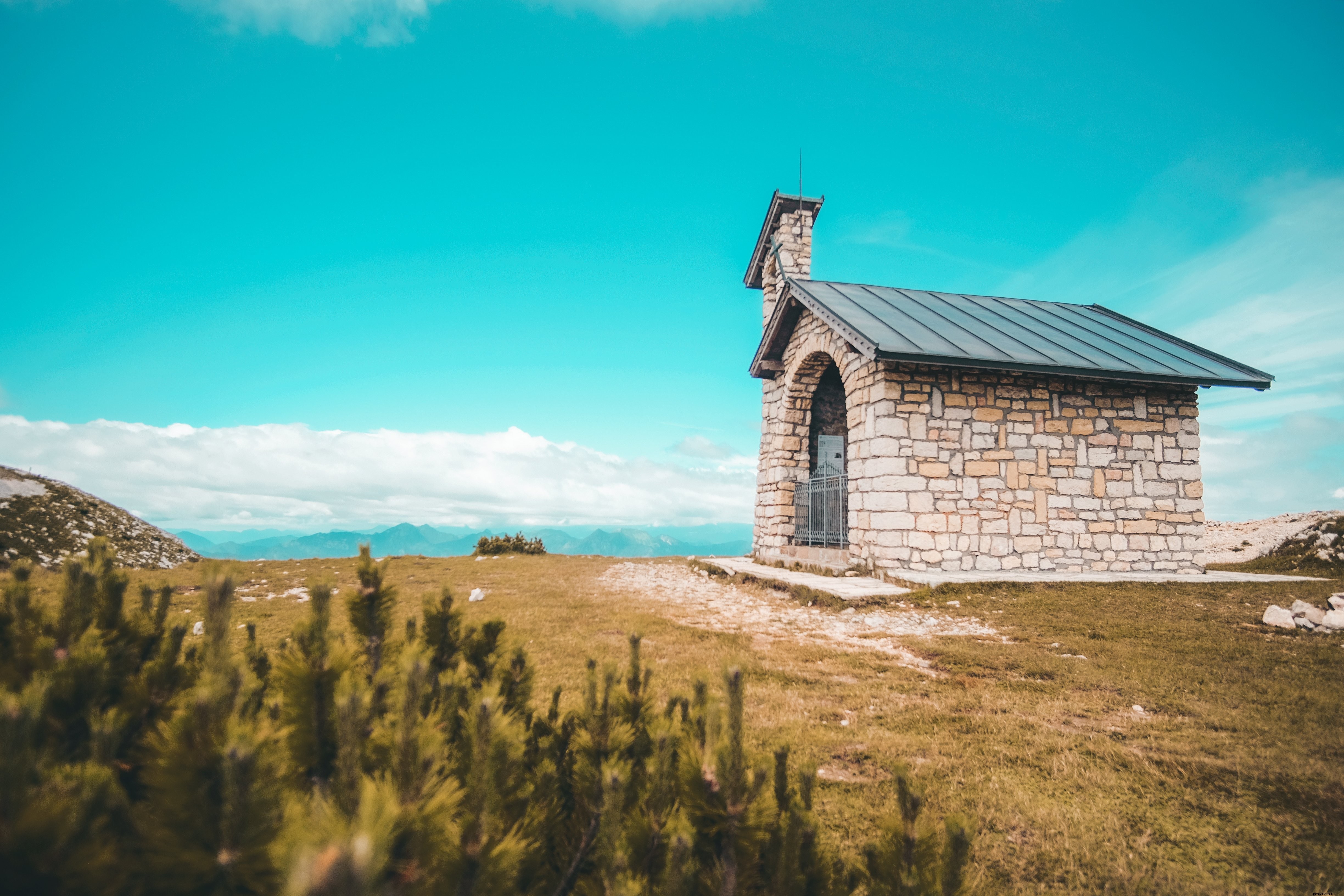 Majestic Stone Church Perched on Grassy Hilltop: Stunning Landscape Photo