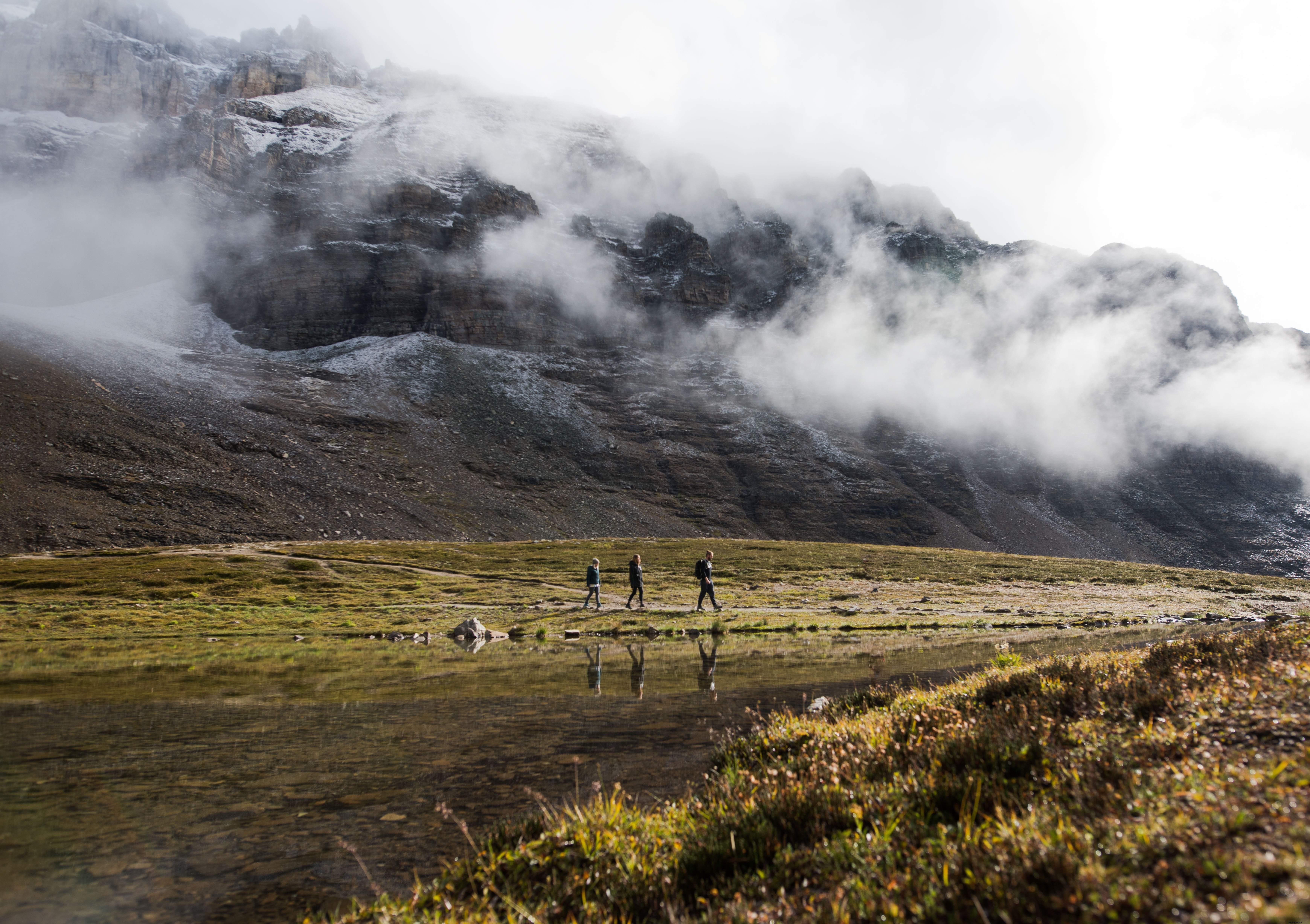 Stunning Photo: Hikers Trekking Beneath the Misty Mountains