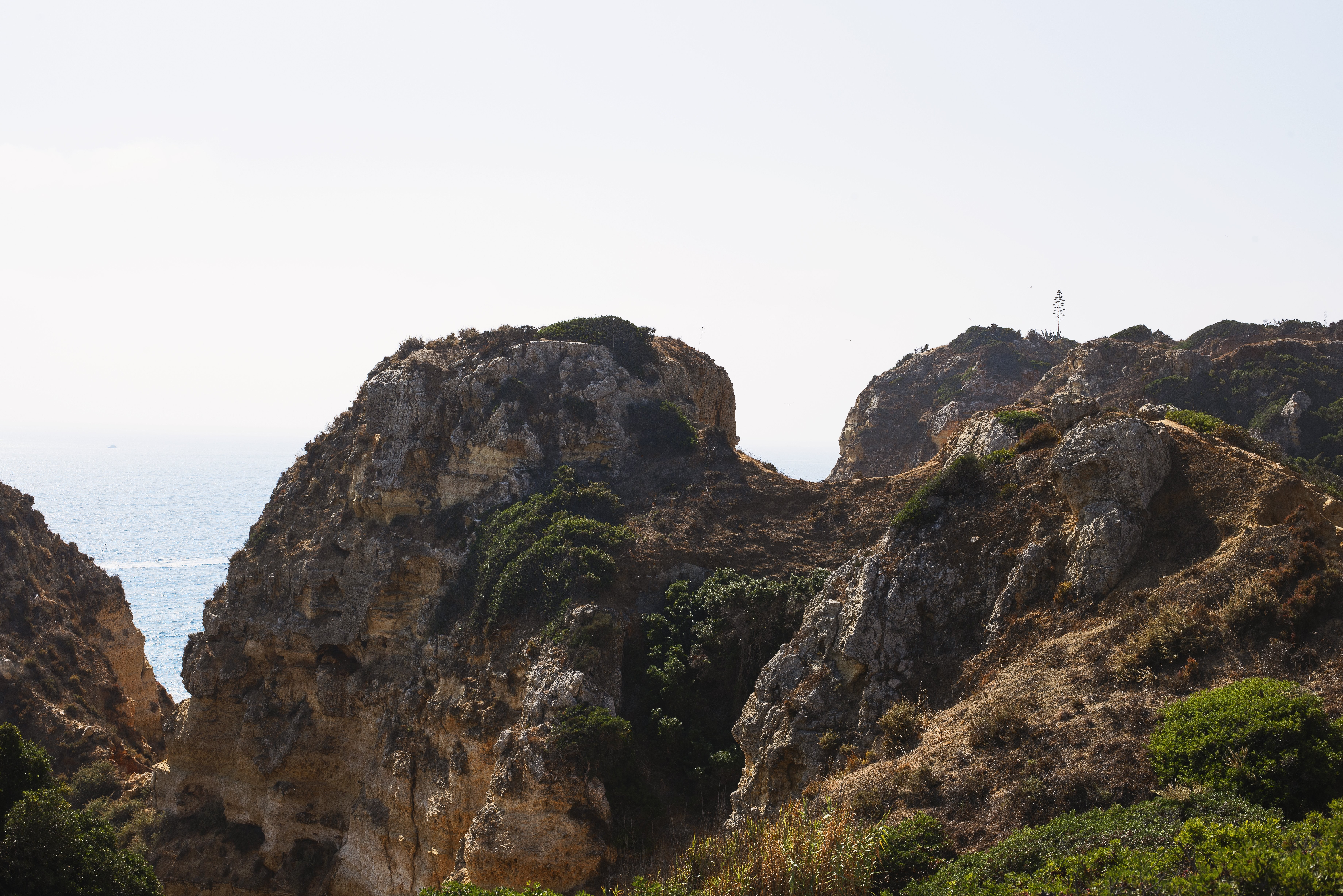 Breathtaking Cliffside Peek to the Endless Sea – Stunning Photo