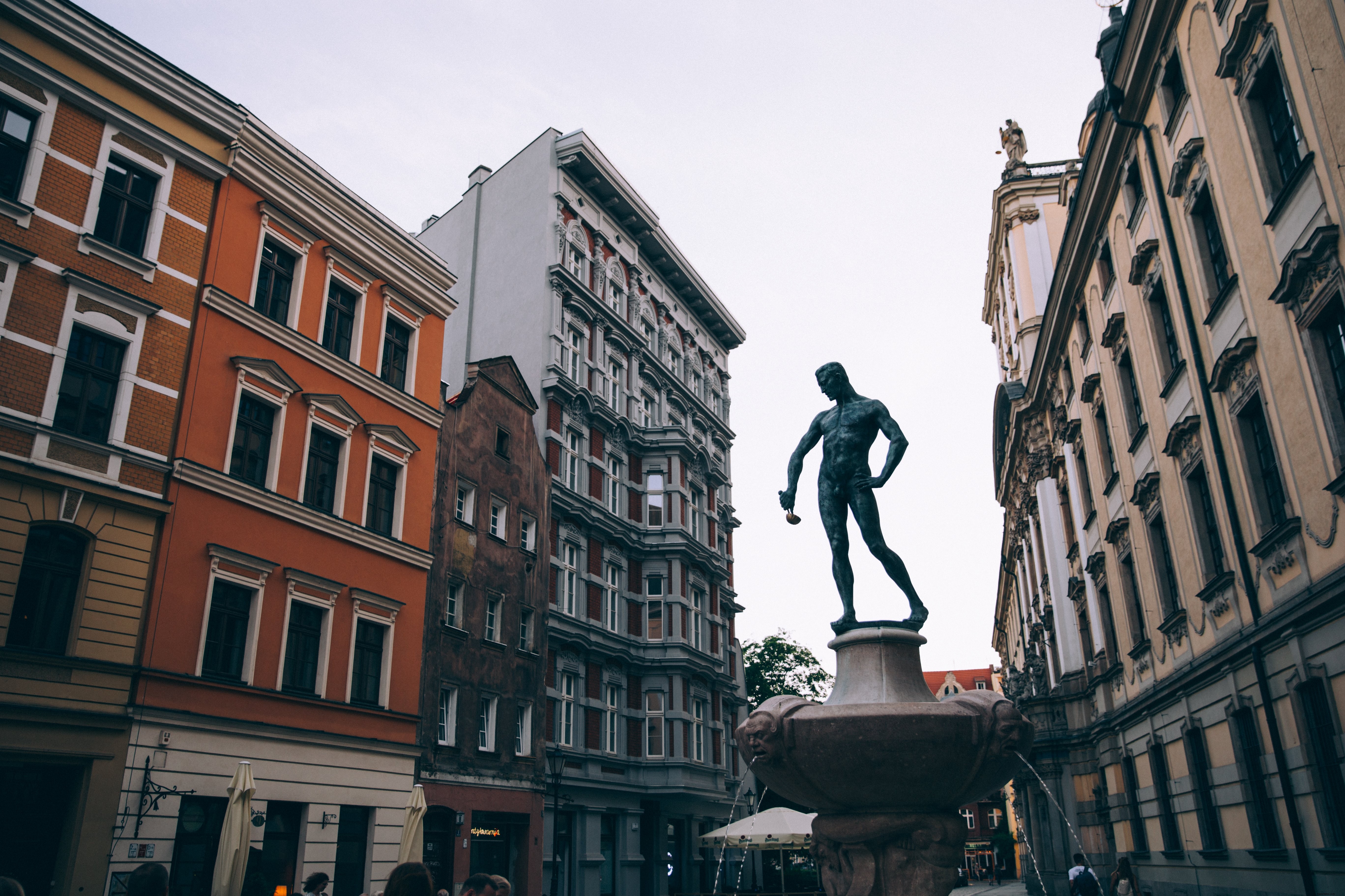 Stunning Photo of Man Holding Ladle Statue in Historic Town Square
