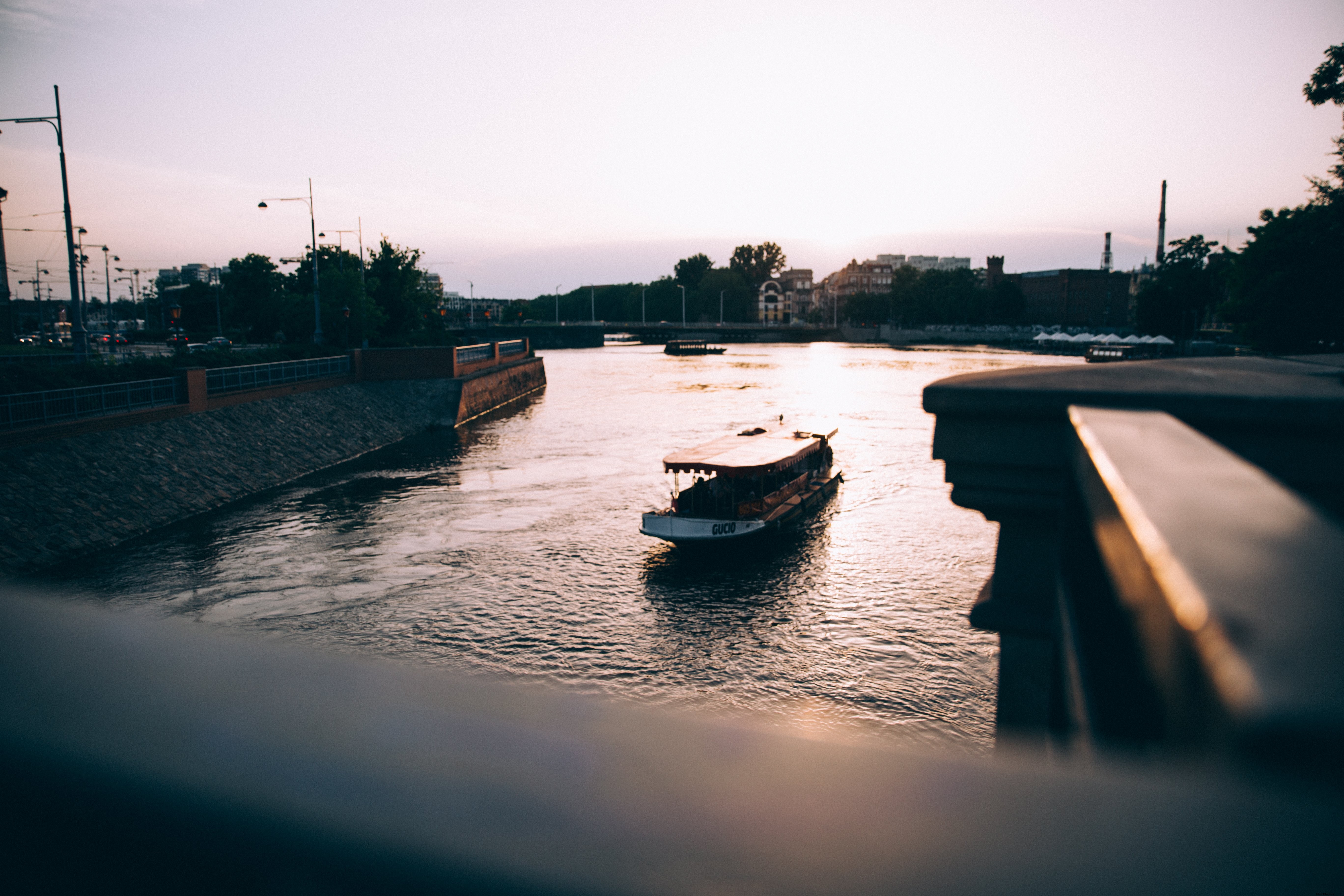 Stunning Sunset: Tourist Boat Gliding on Serene River – Captivating Photo