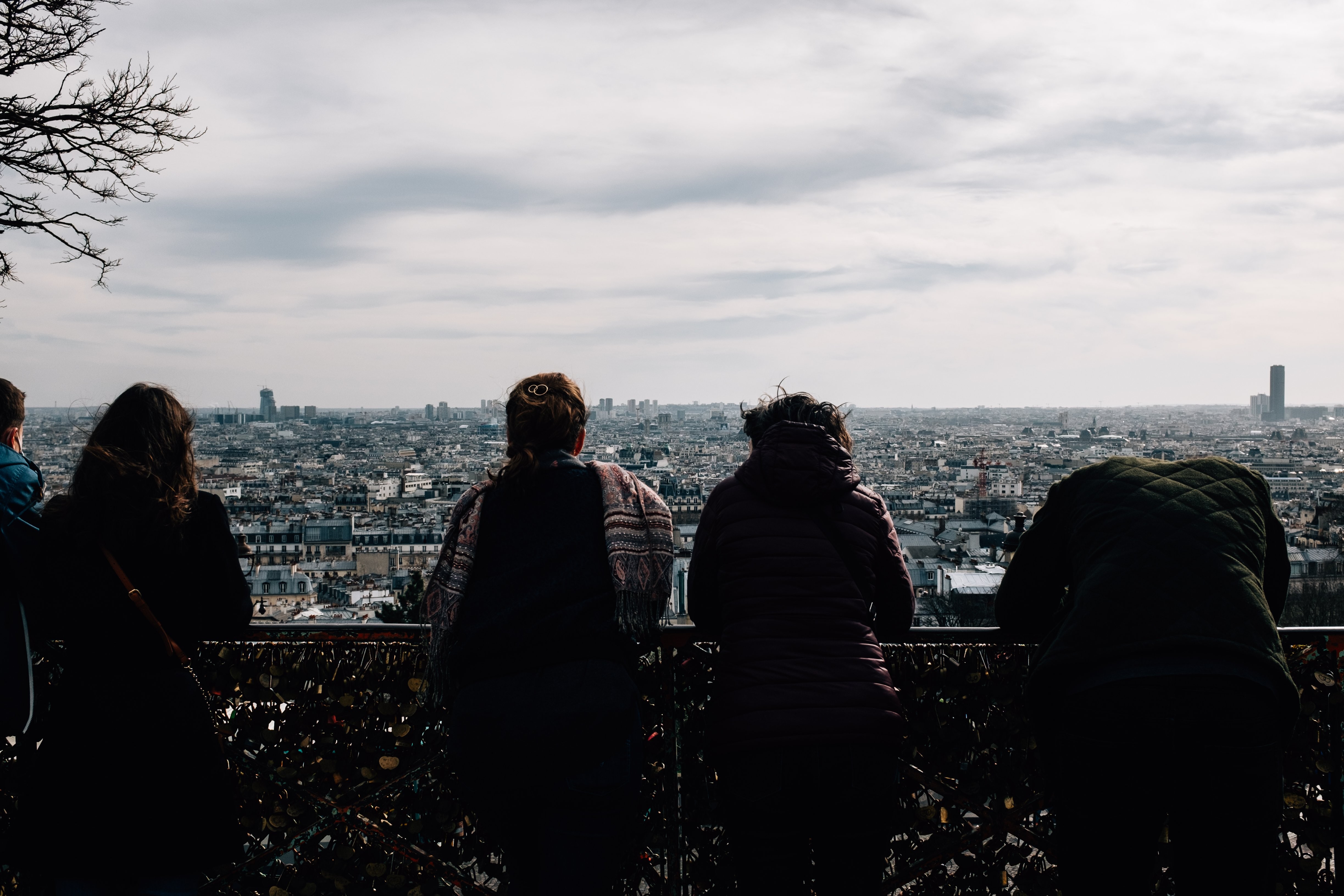 Stunning Urban Photo: People Gazing at City Skyline from Fence