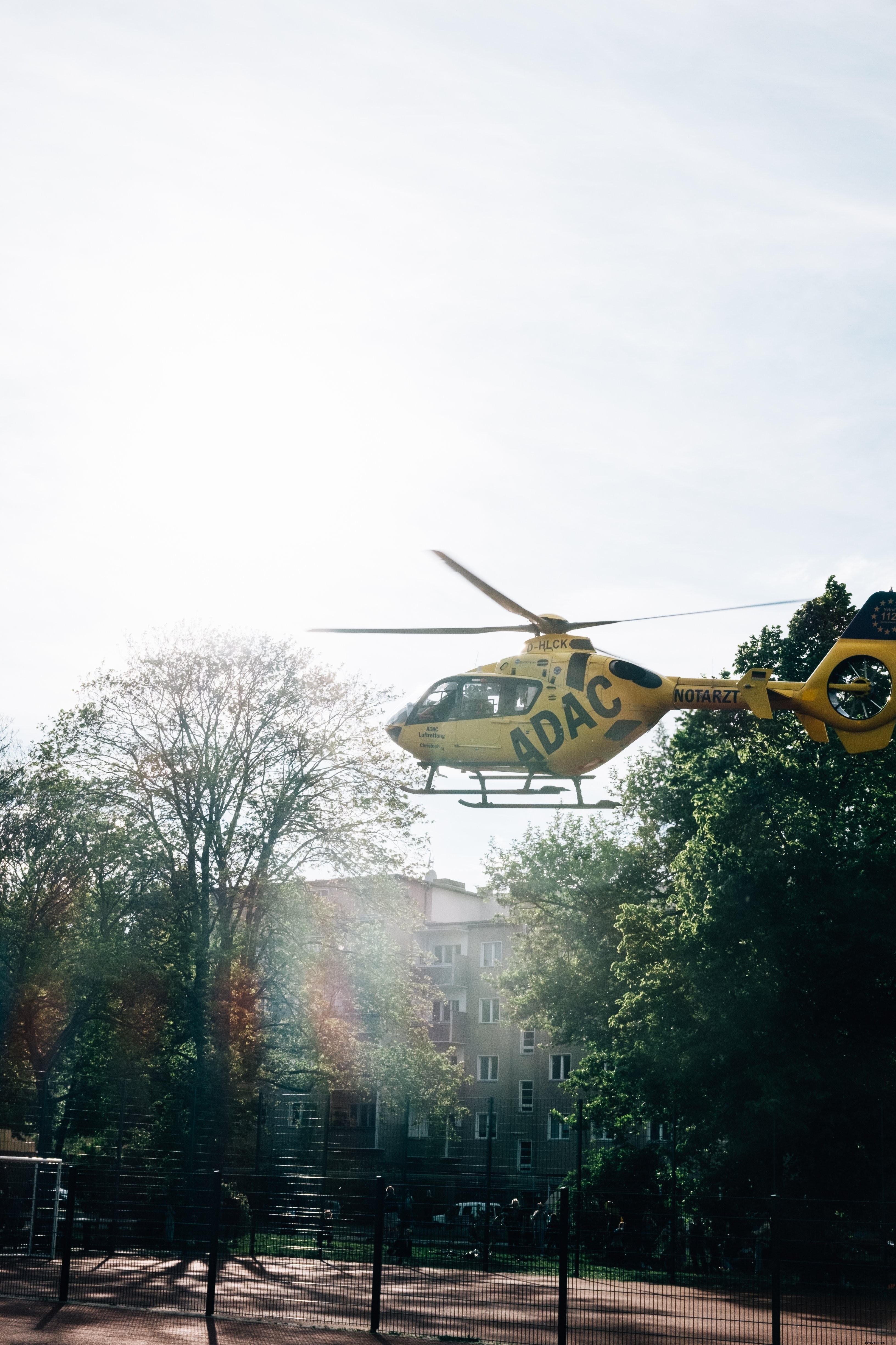 Stunning Photo: Yellow Helicopter Lands in Bustling Town