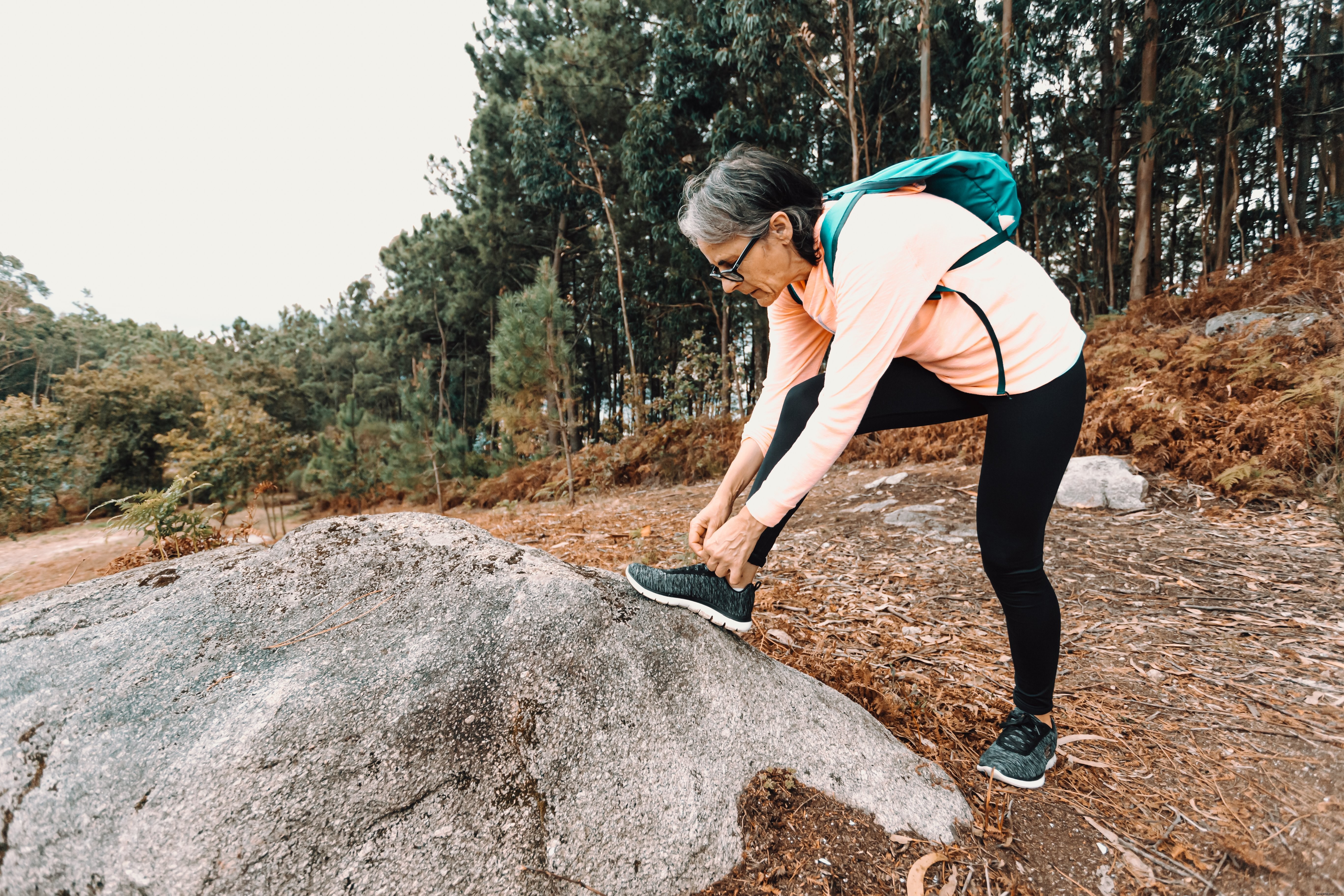 Woman Pauses on Hiking Trail to Tie Her Shoe – Captivating Photo