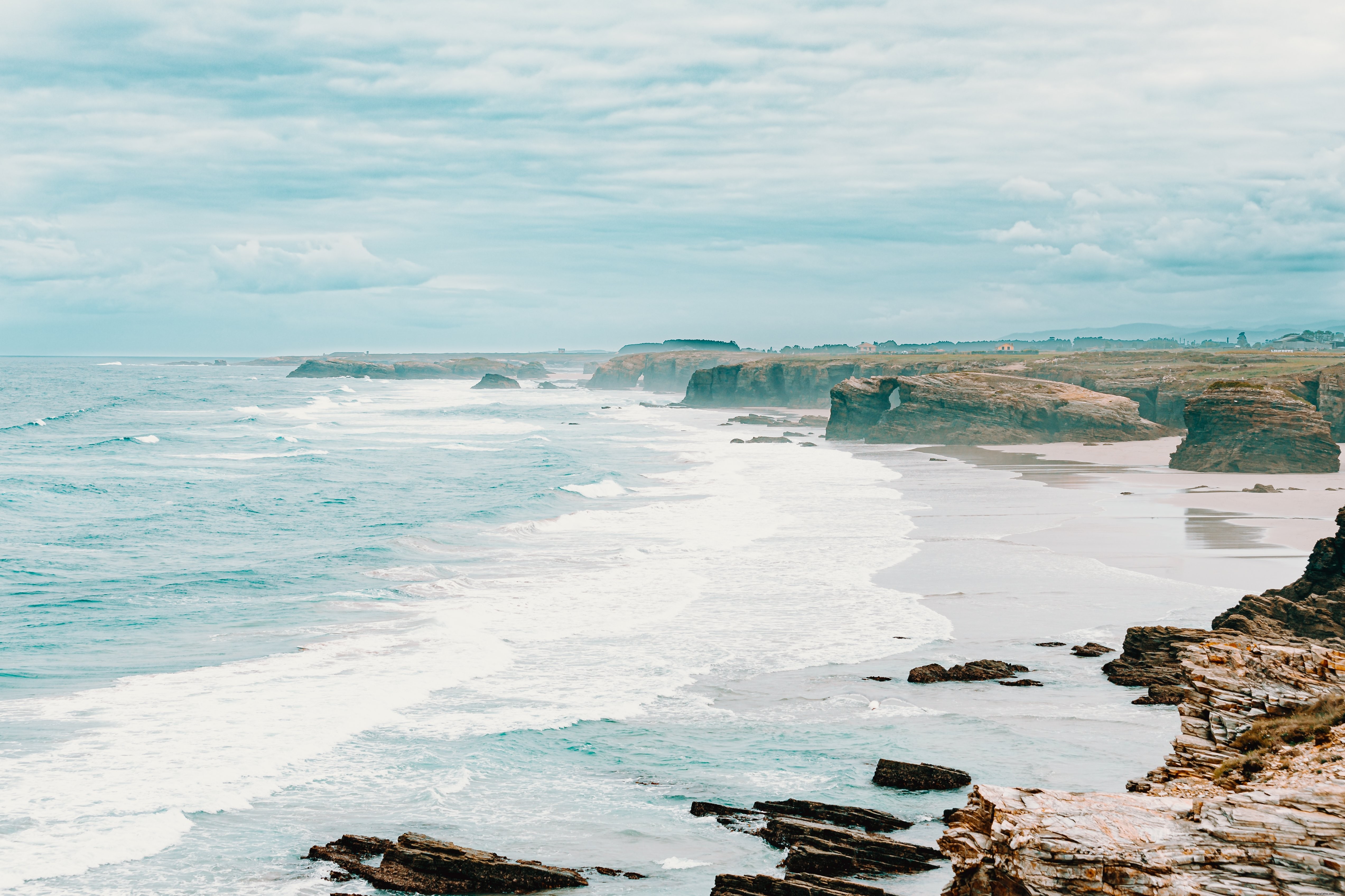 Hazy Dawn: Tide Rushes onto Shore in Stunning Morning Photo
