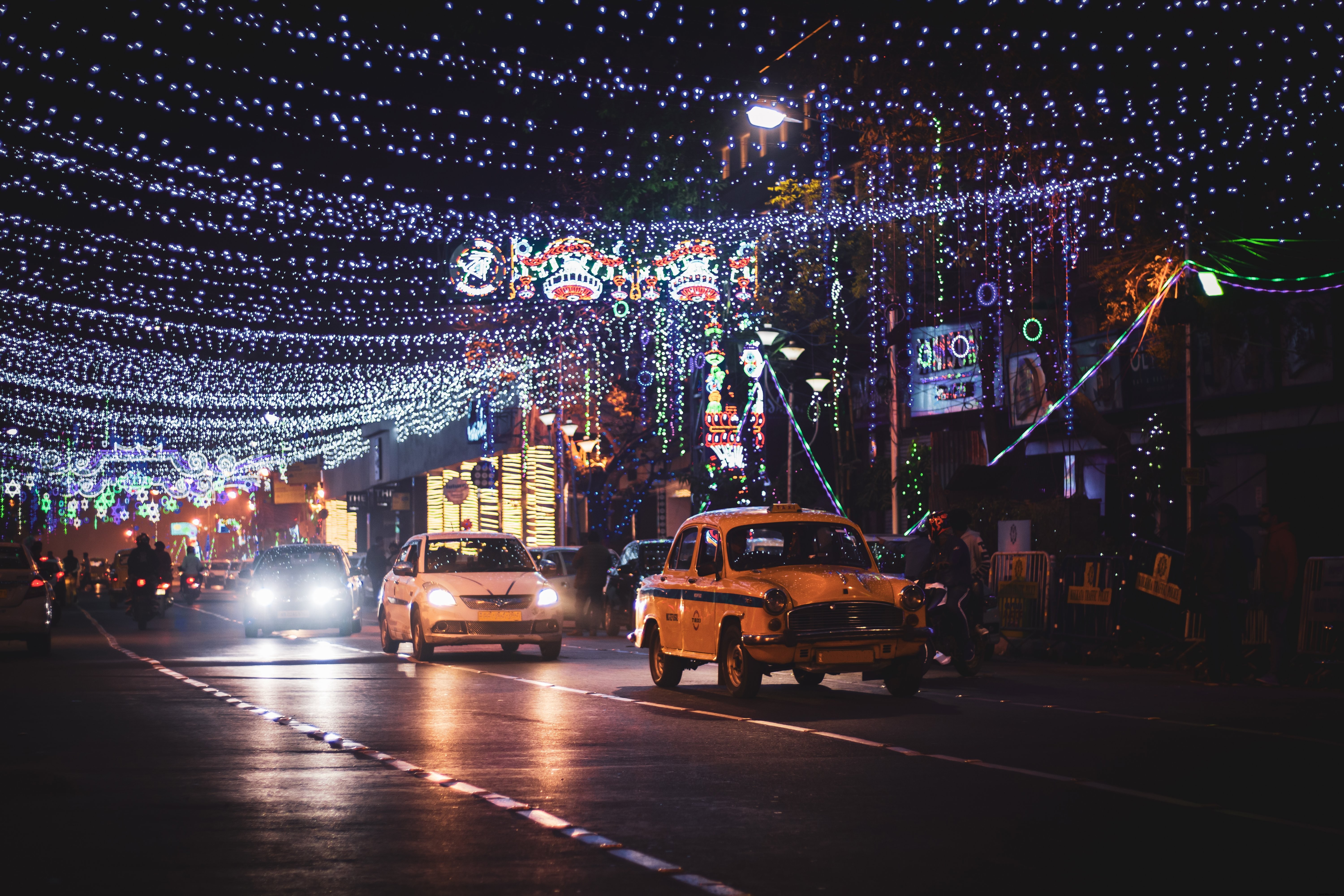 Stunning Night Photo: Taxis and Compact Cars on Vibrant Lit City Street