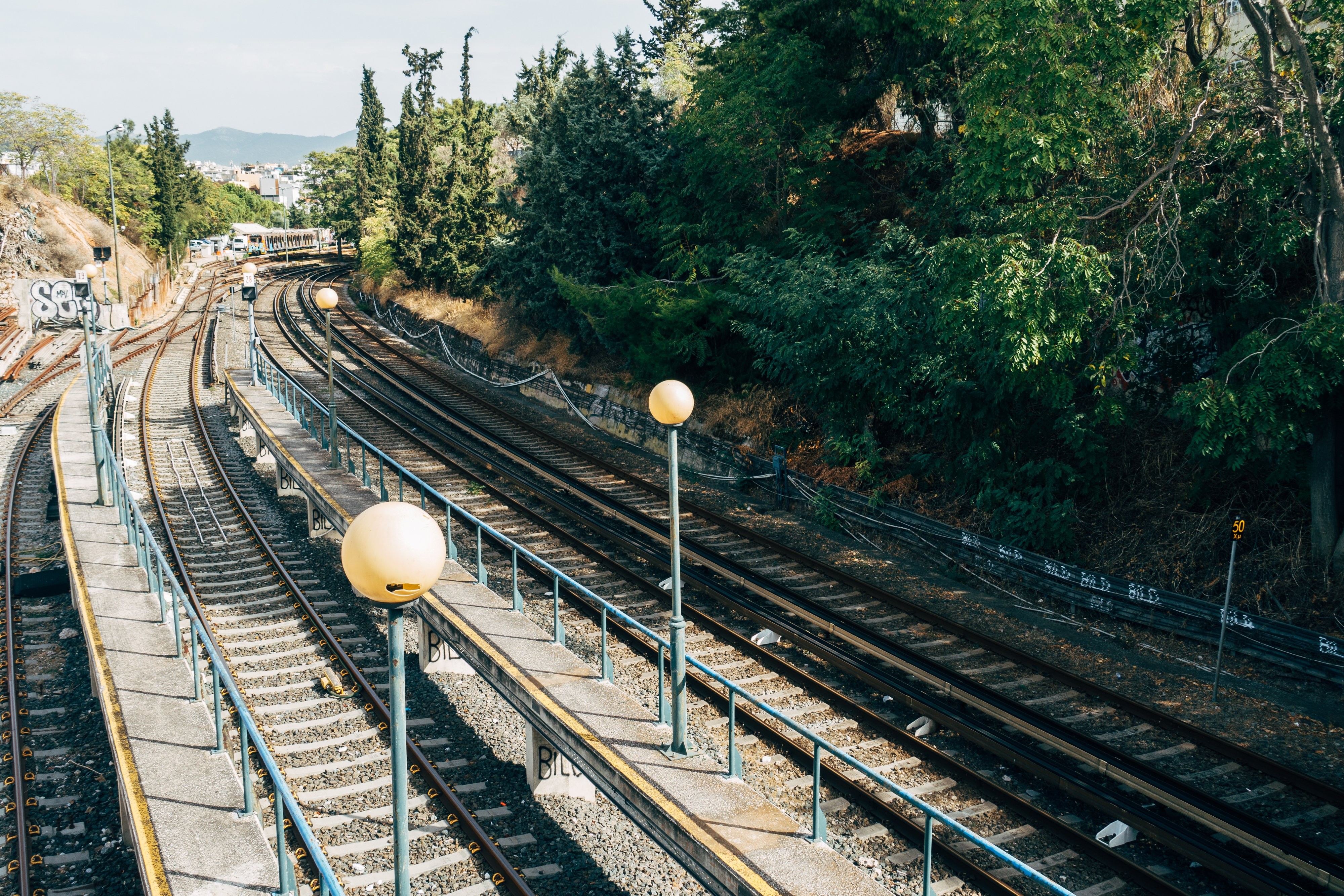 Stunning Train Tracks Lined with Lush Green Trees – Captivating Photo