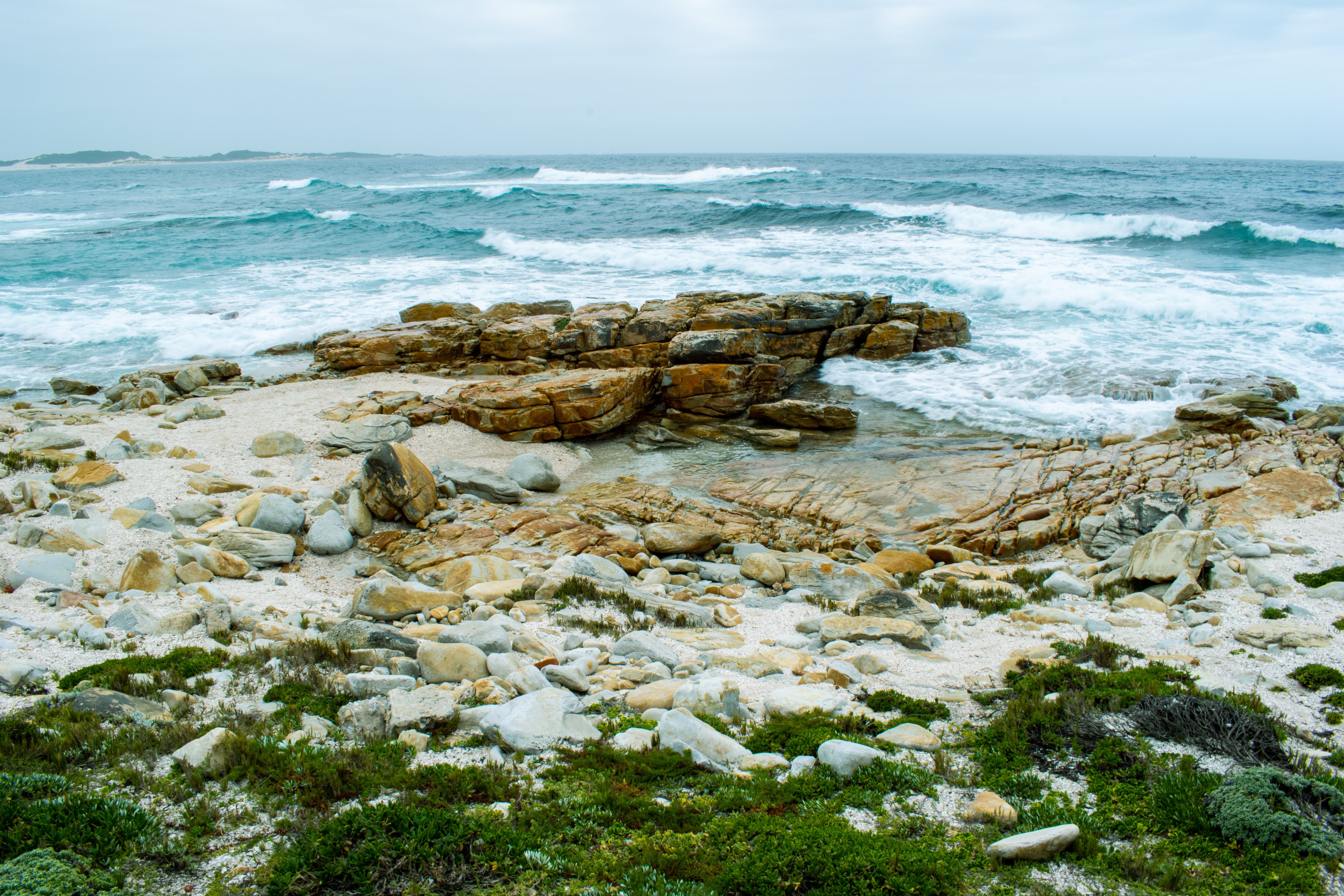 Stunning Deep Blue Waves Crashing Against Rugged Rocks – Captivating Ocean Photo