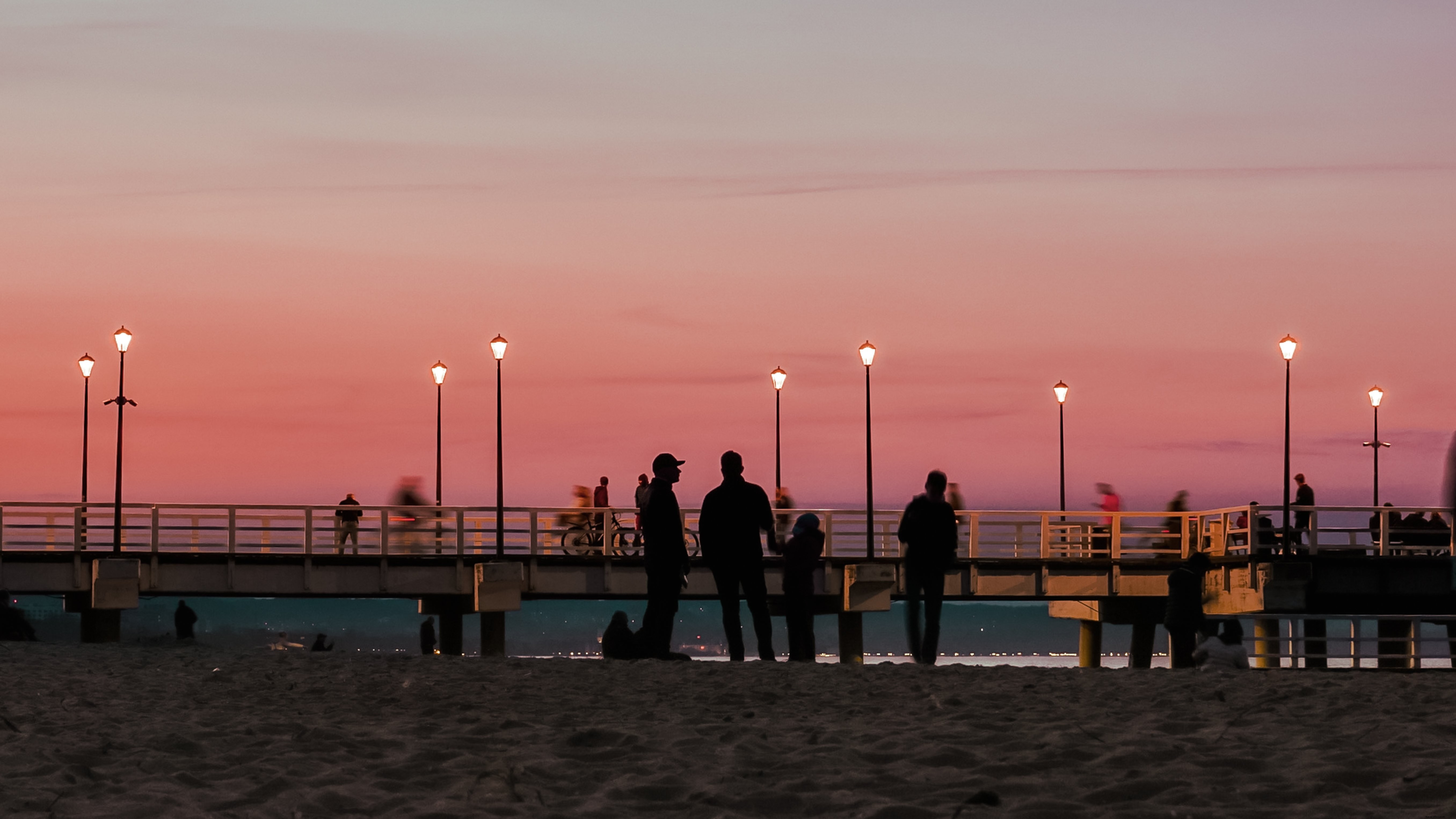 Stunning Beach Pier Sunset: People Enjoying the View Photo