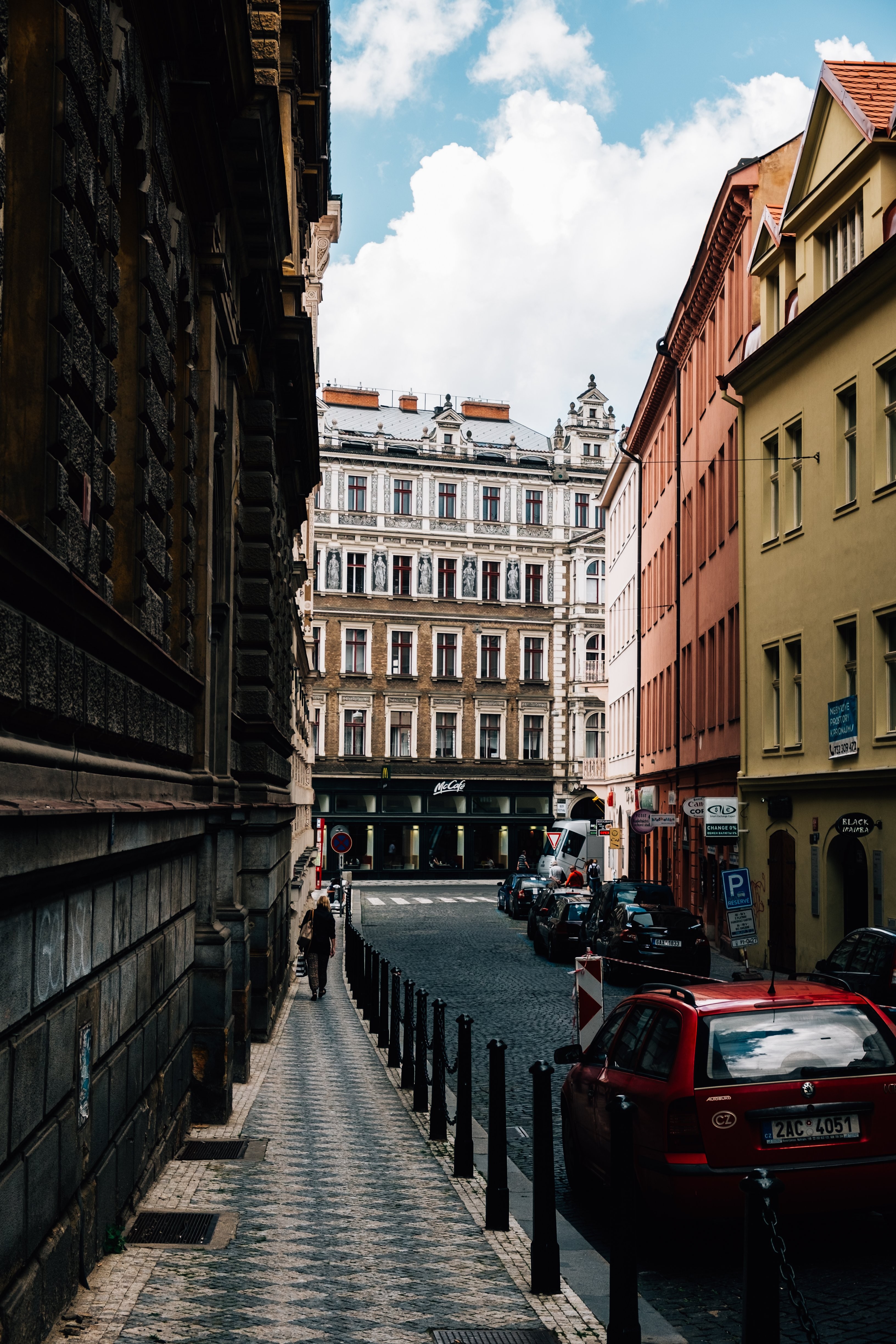 Towering Skyscrapers Frame Narrow Urban Street with Parked Cars – Stunning Photo