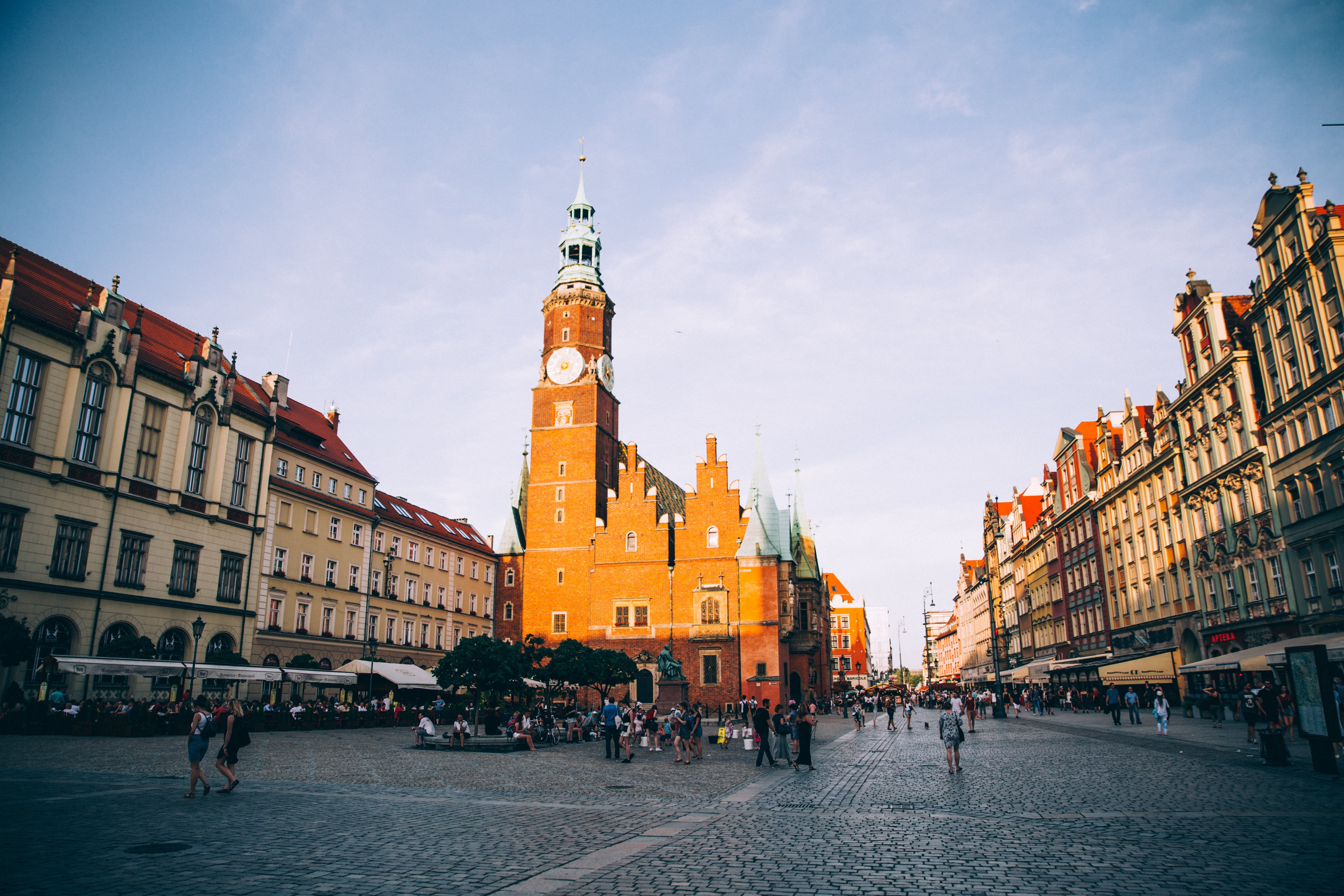Stunning Sunset: Red Brick Clock Tower and Historic Church in Vibrant Piazza