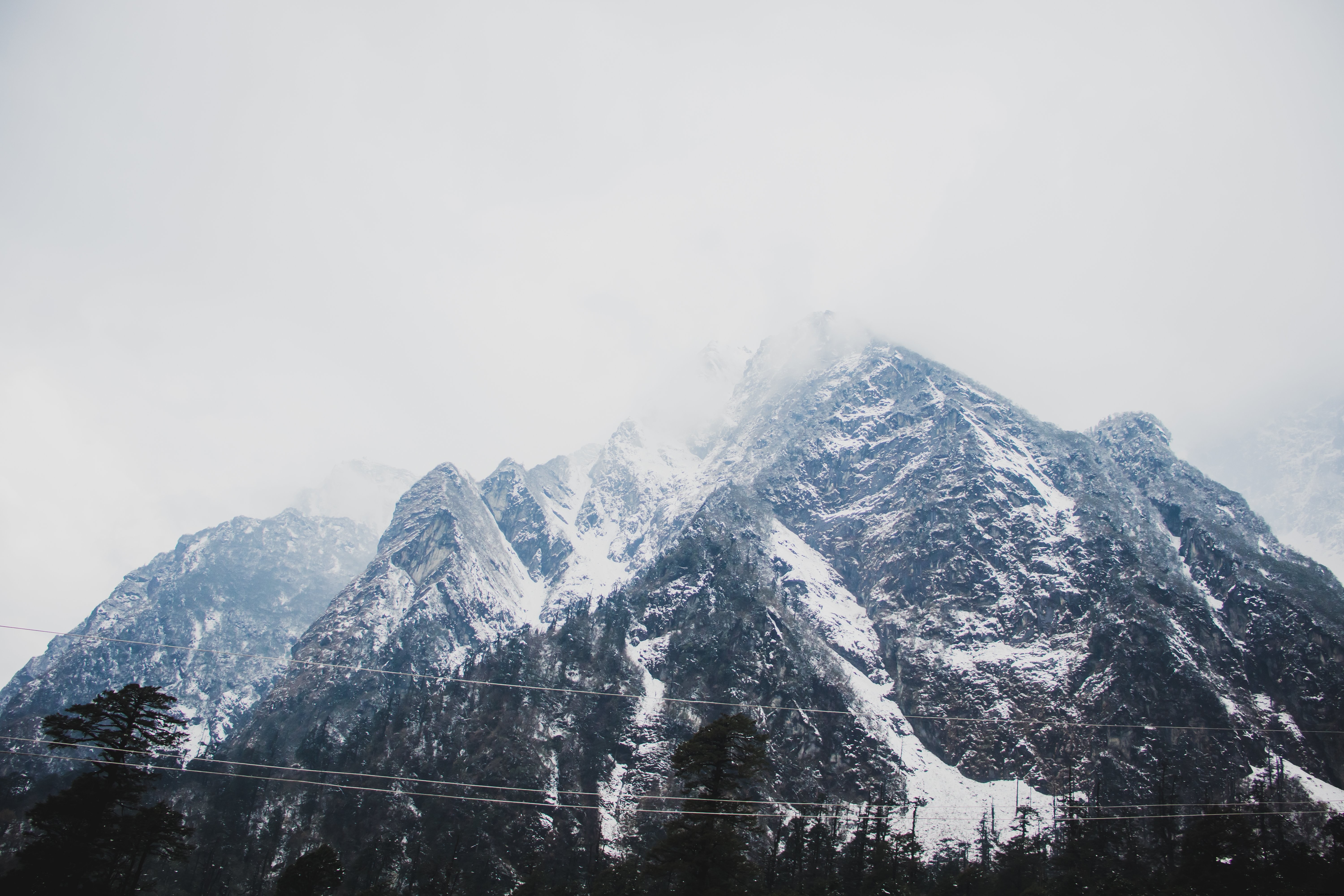Breathtaking Snow-Capped Mountains Shrouded in Clouds – Stunning Landscape Photo