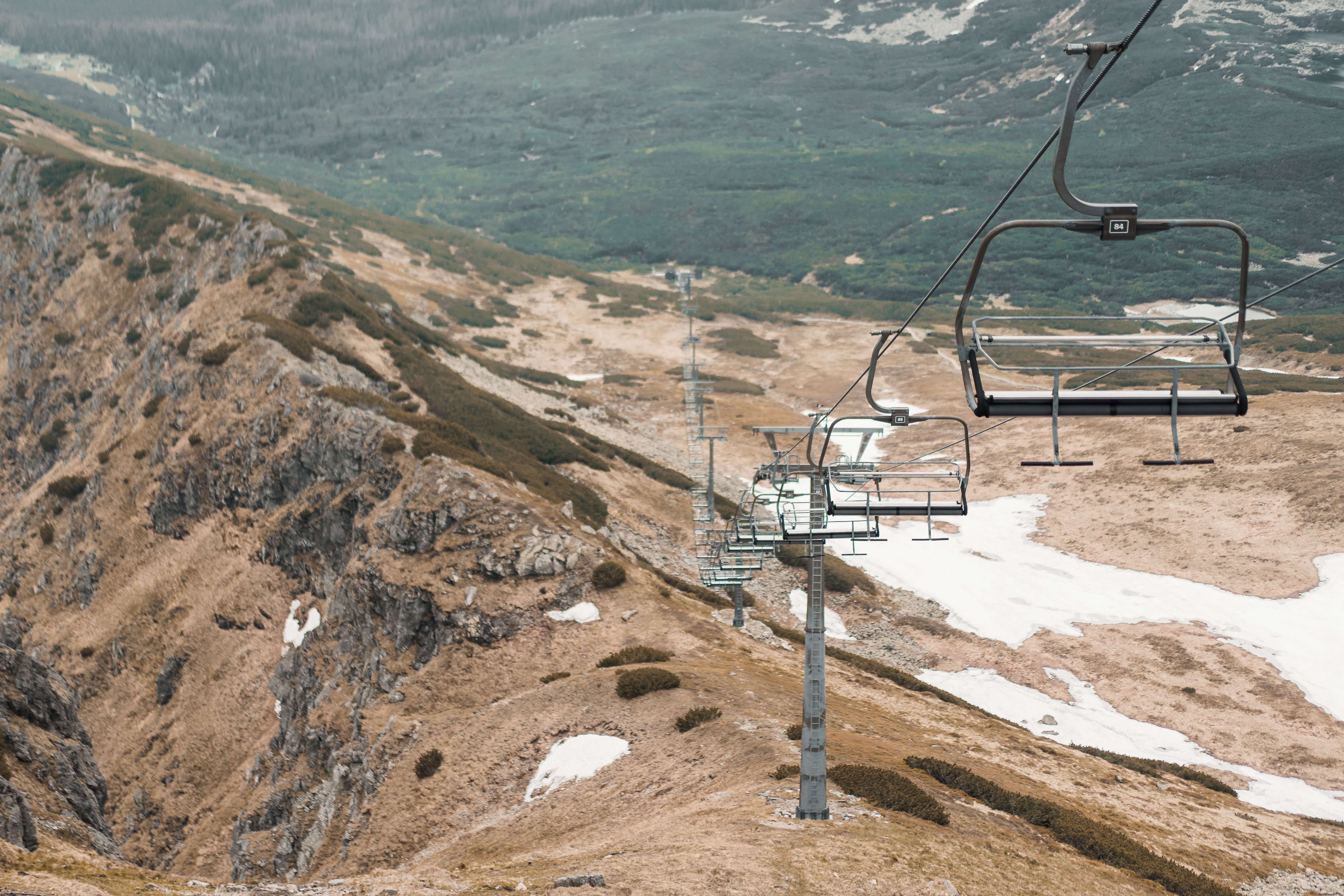 Stunning Chairlift Over Snow-Patched Hills – Captivating Winter Photo