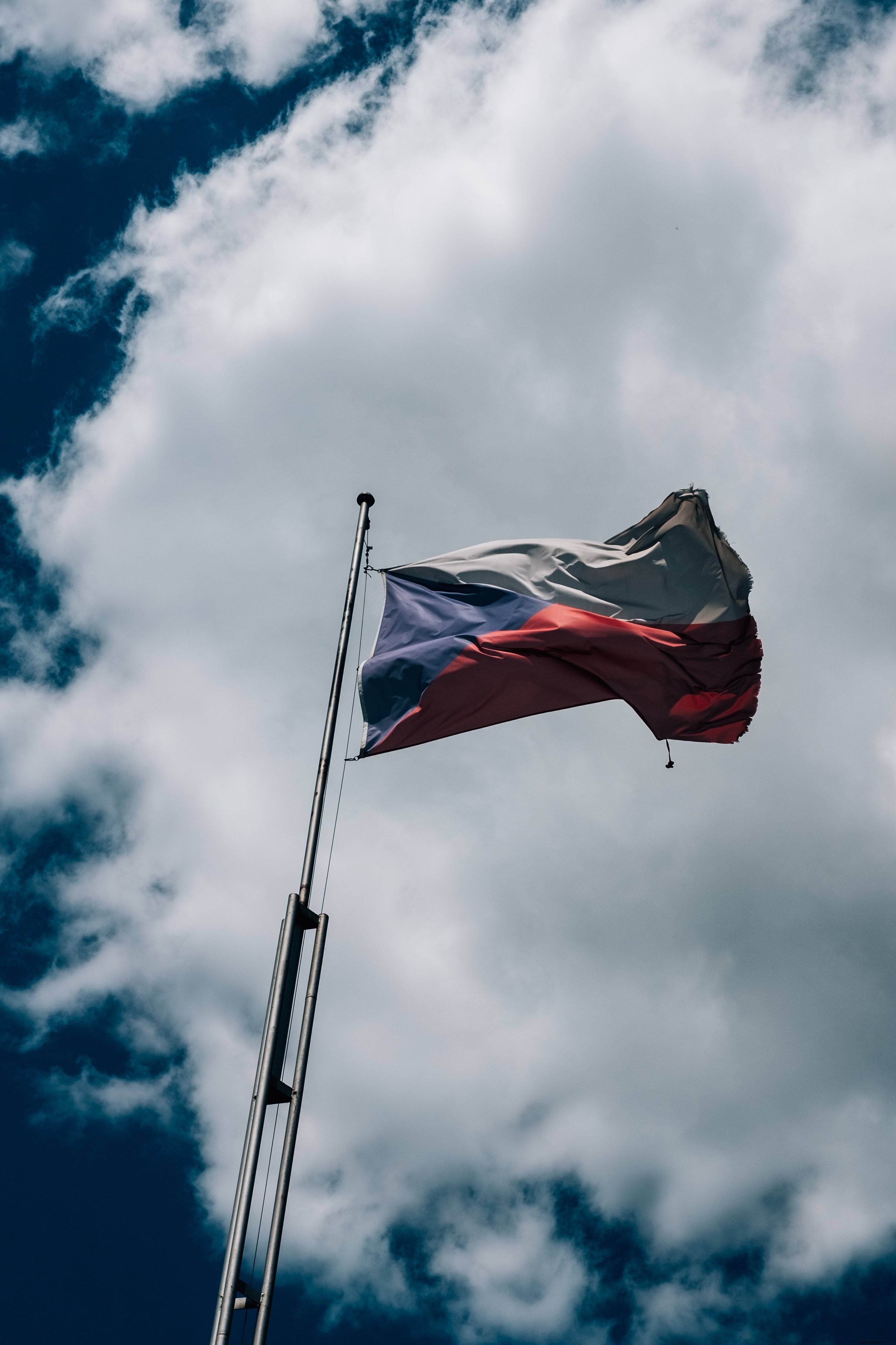 Stunning Czech Flag Waving Against a Dramatic Cloudy Blue Sky – High-Quality Photo