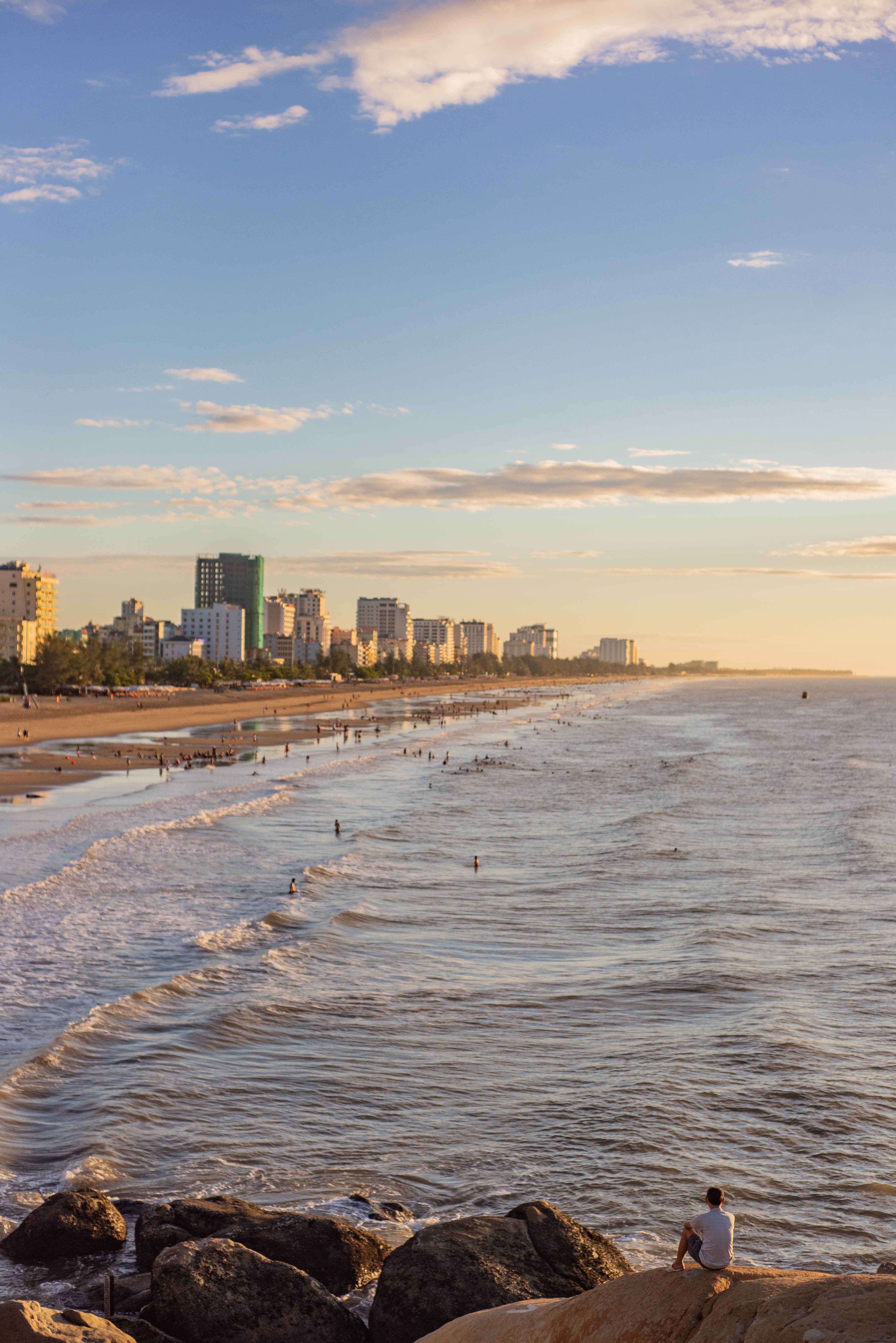Vibrant Bustling Beach Framed by Towering City Skyline – Stunning Coastal Photo