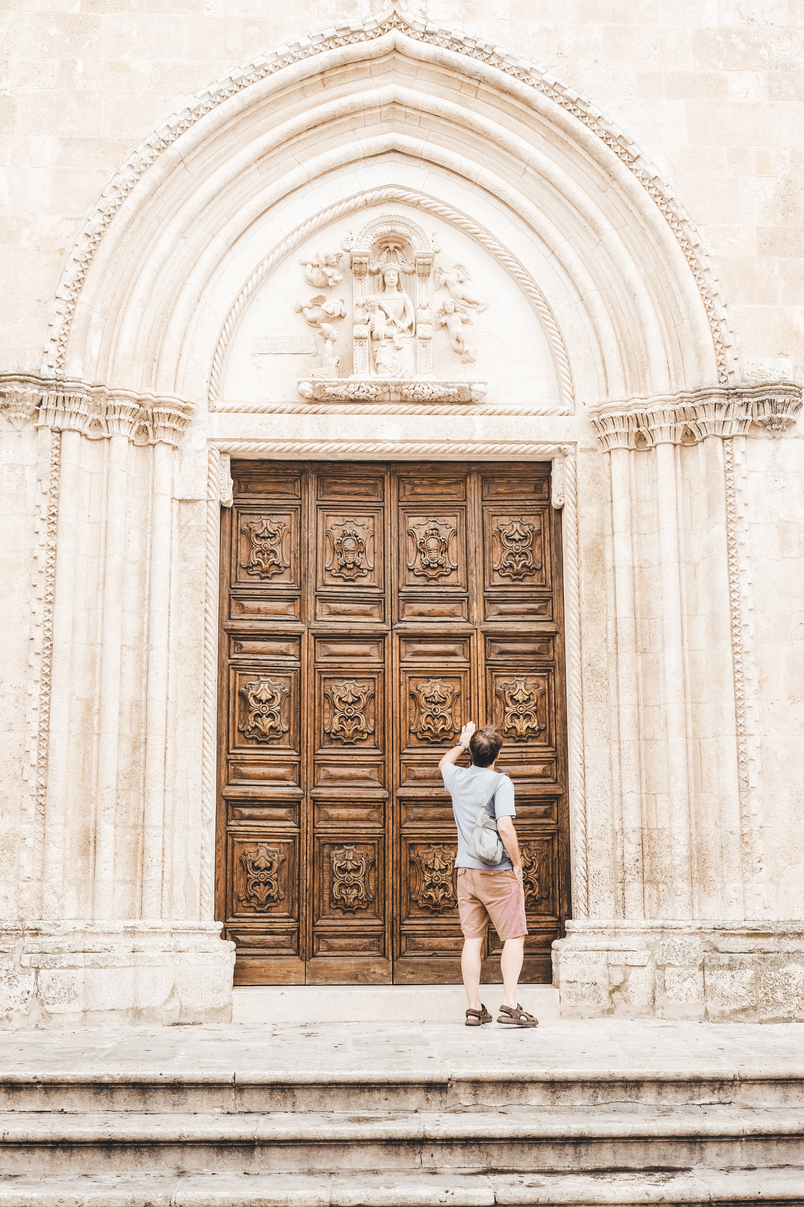 Captivating Photo: Person Knocking on Grand Wooden Doorway
