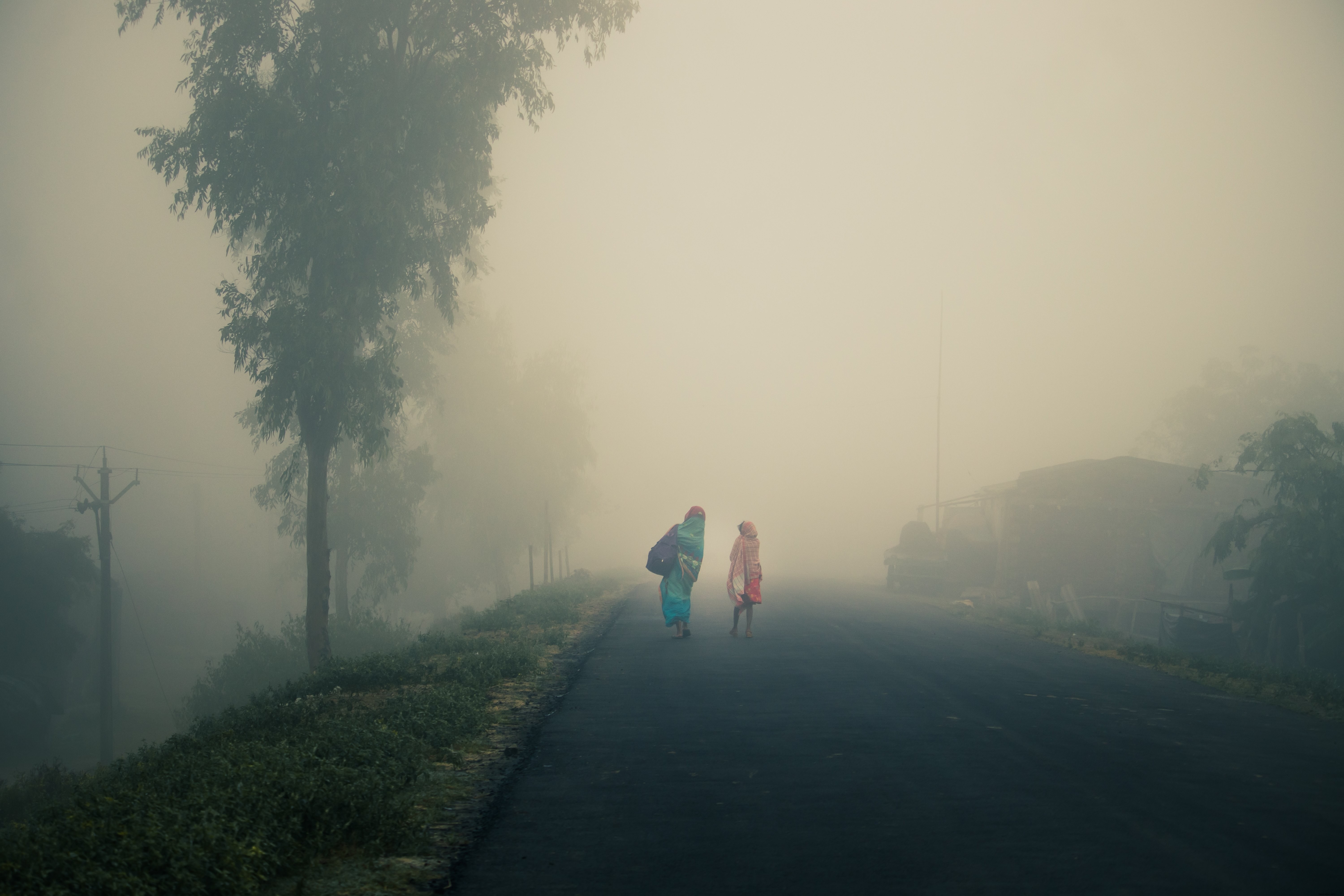 Two People Walking on an Empty Foggy Road – Stunning Atmospheric Photo