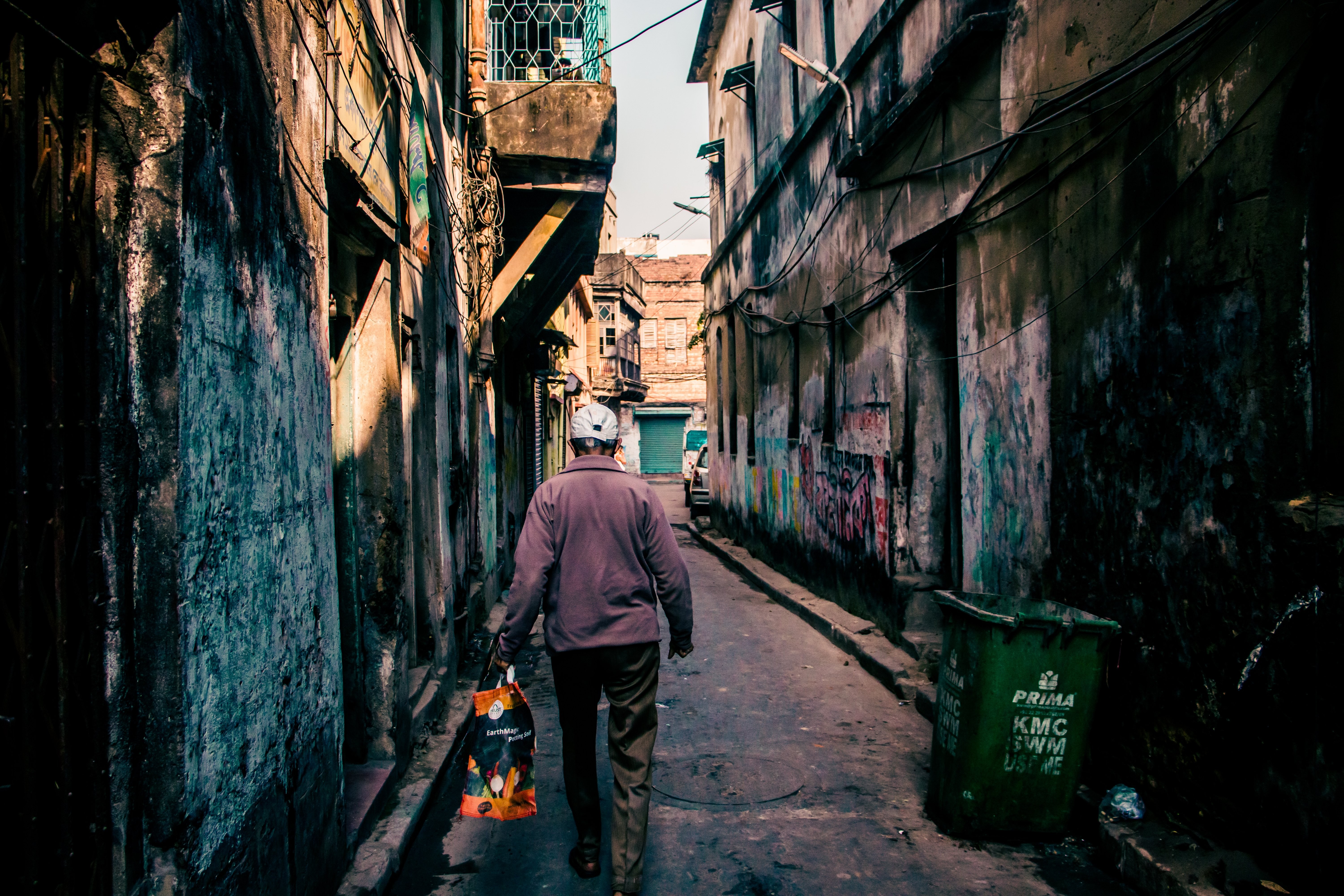 Captivating Urban Scene: Person Strolling Through Graffiti-Covered Alley
