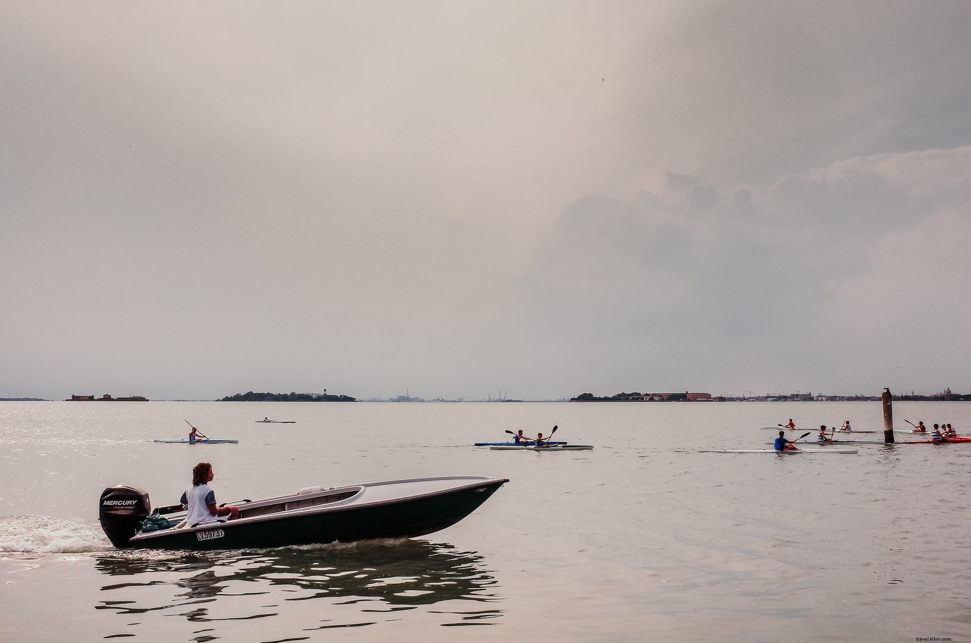Kayakers Paddle on a Cloudy Day with Trailing Boat – Stunning Scenic Photo