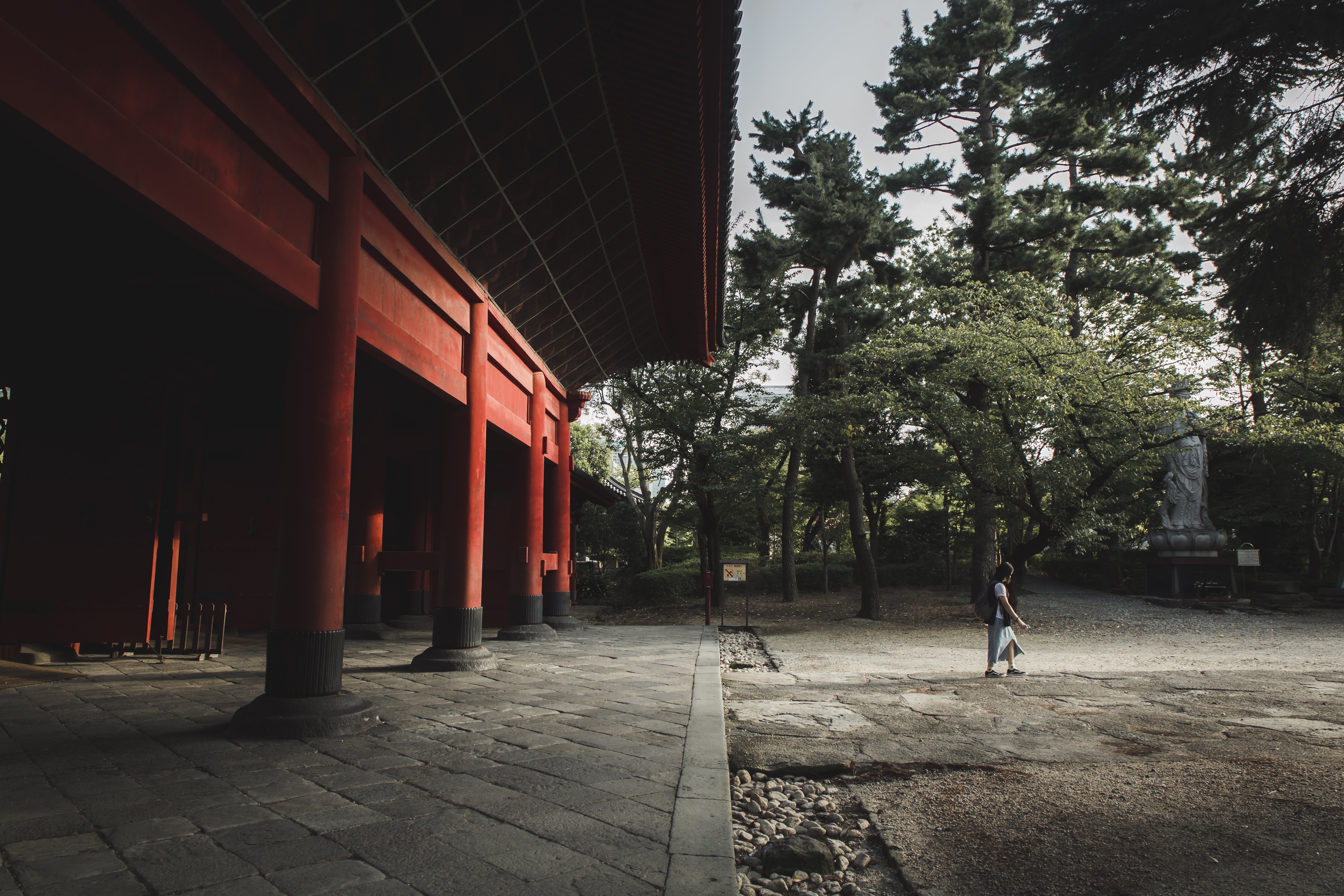 Vibrant Red Building Framed by Lush Trees: Stunning Photo of a Person Walking