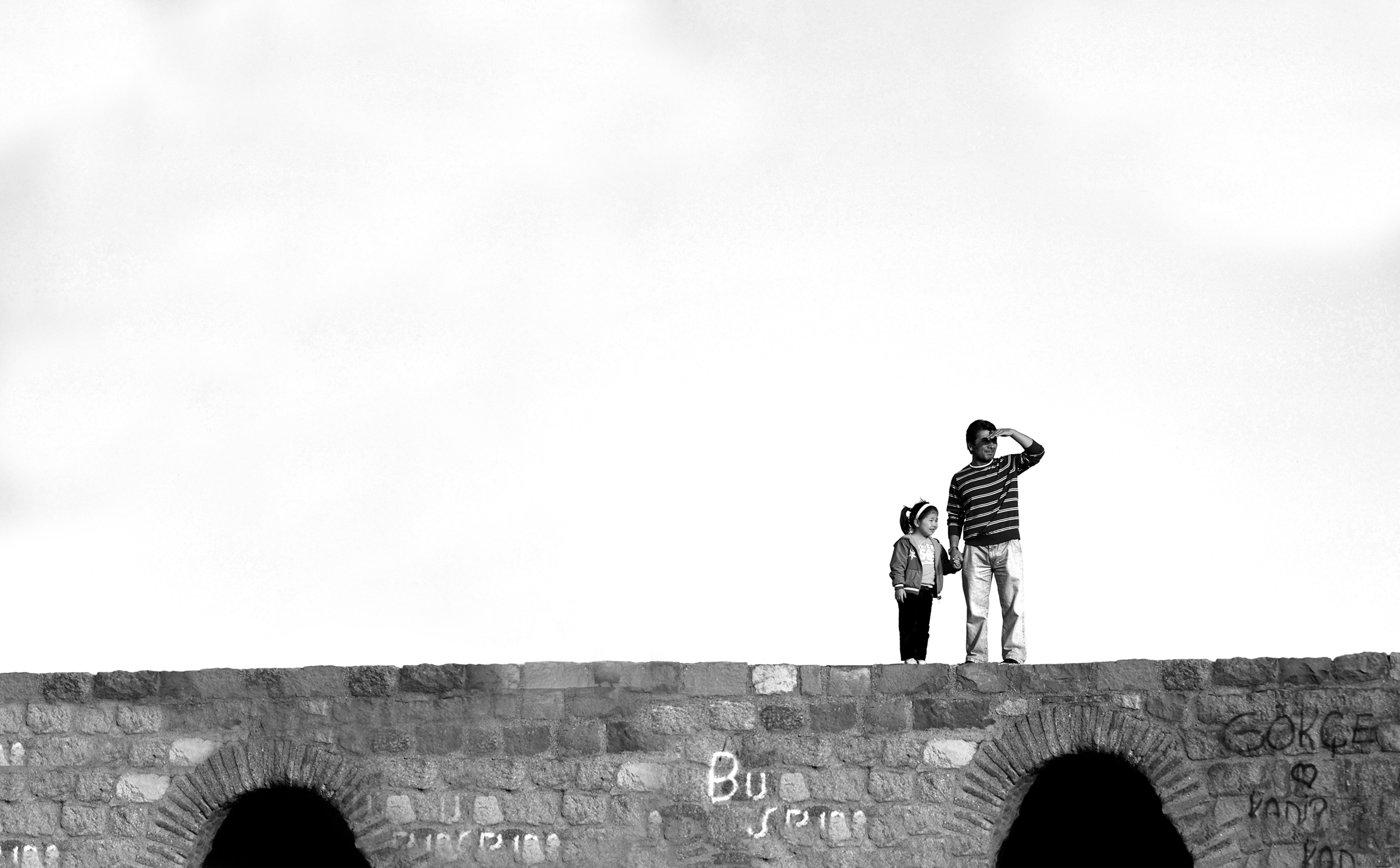 Stunning Black‑and‑White Portrait of Two Individuals on a Historic Stone Bridge