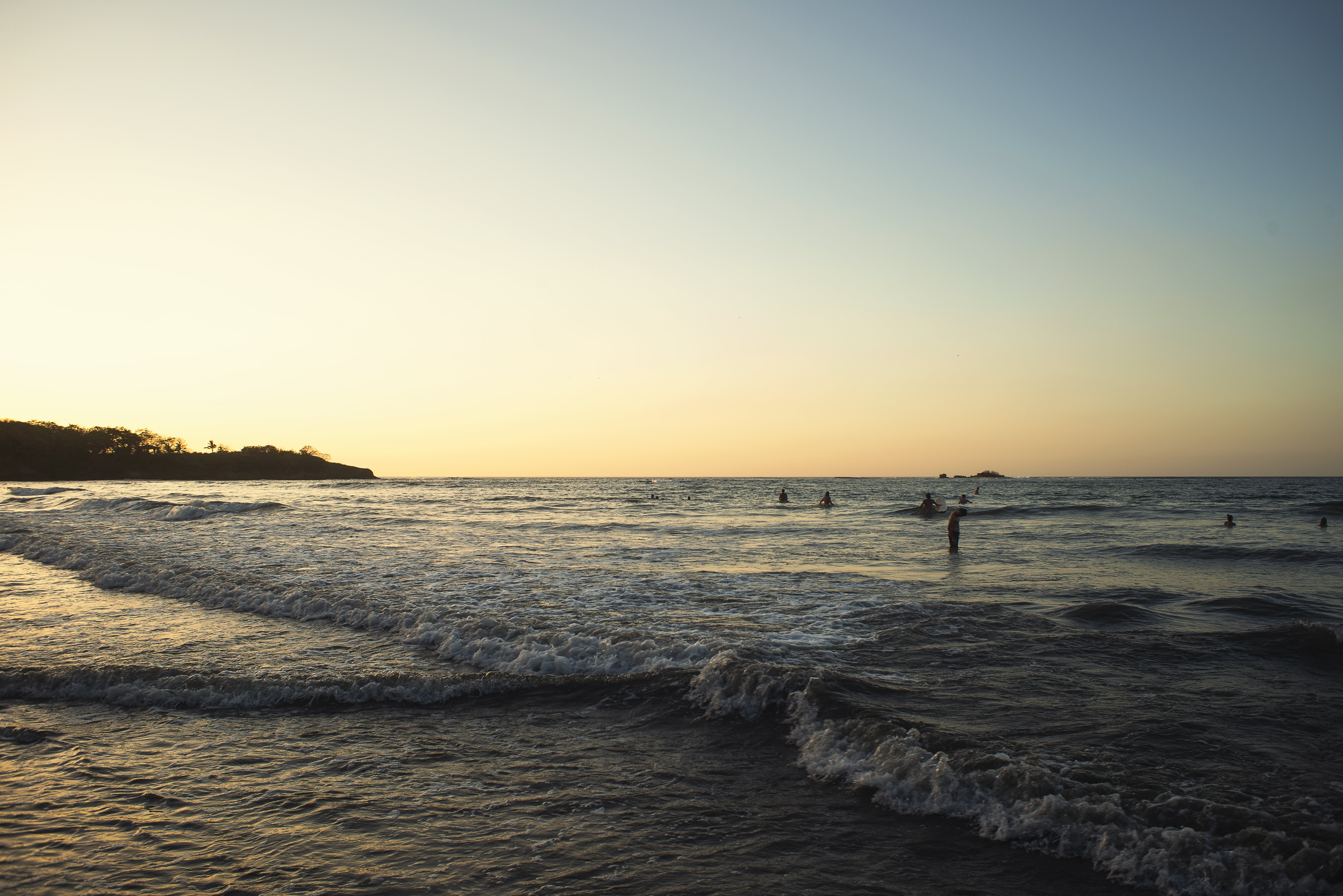 Sunset Over Surfers and Beachgoers: A Stunning Coastal Scene