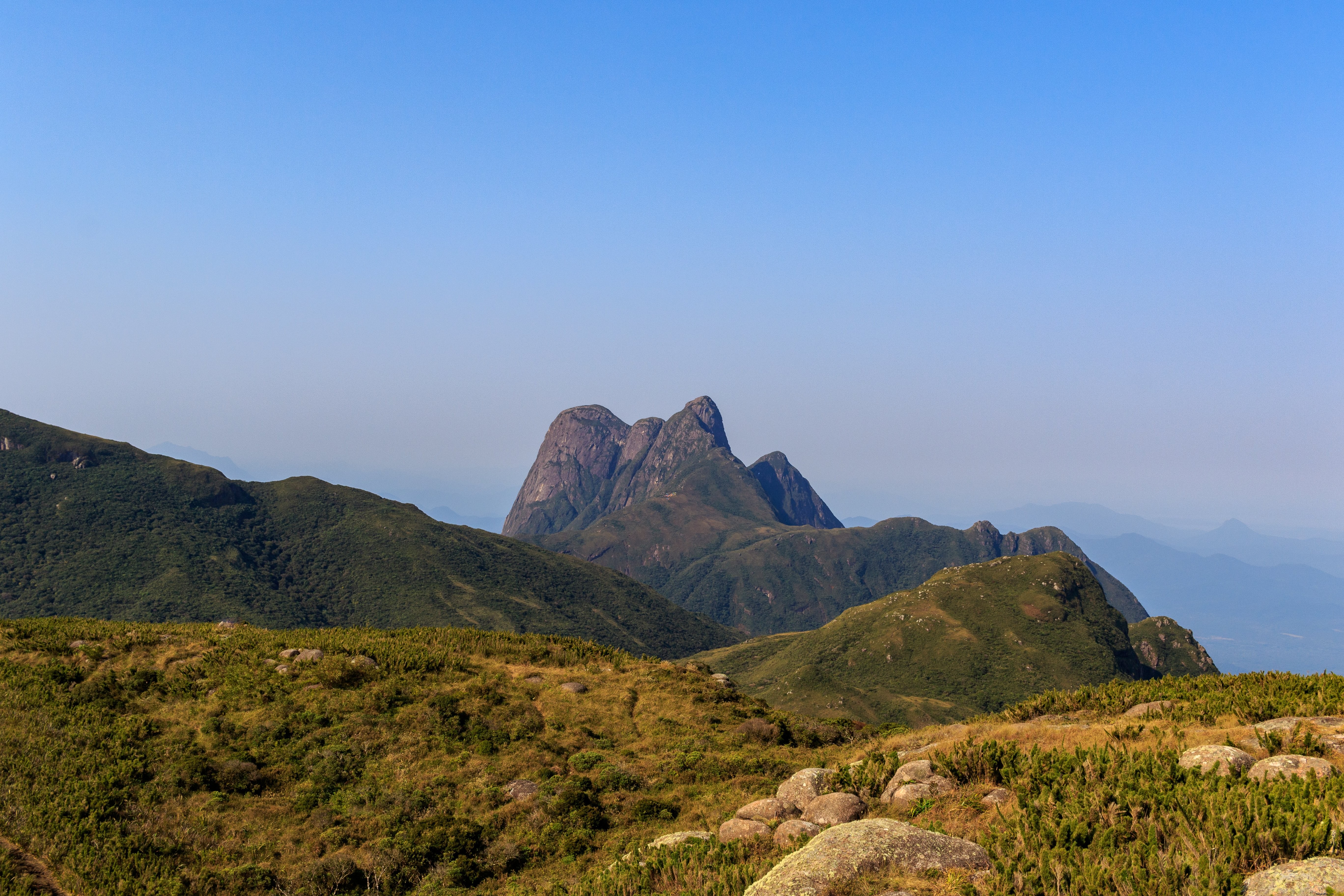 Scenic Landscape of Rolling Green Hills and Mountain Peaks