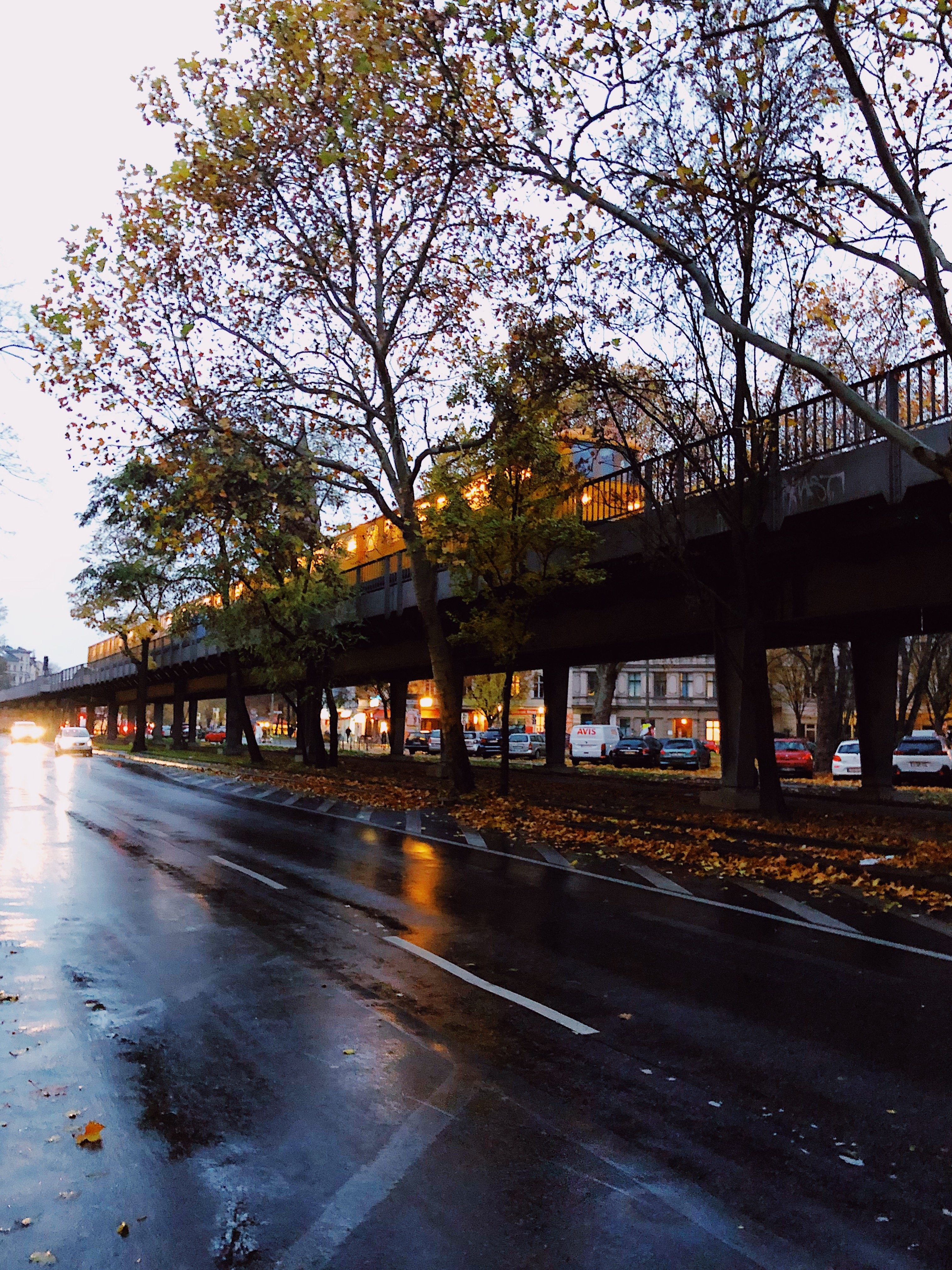 Yellow Train Navigating Tracks Amid Rainy Roads – Stunning Photo