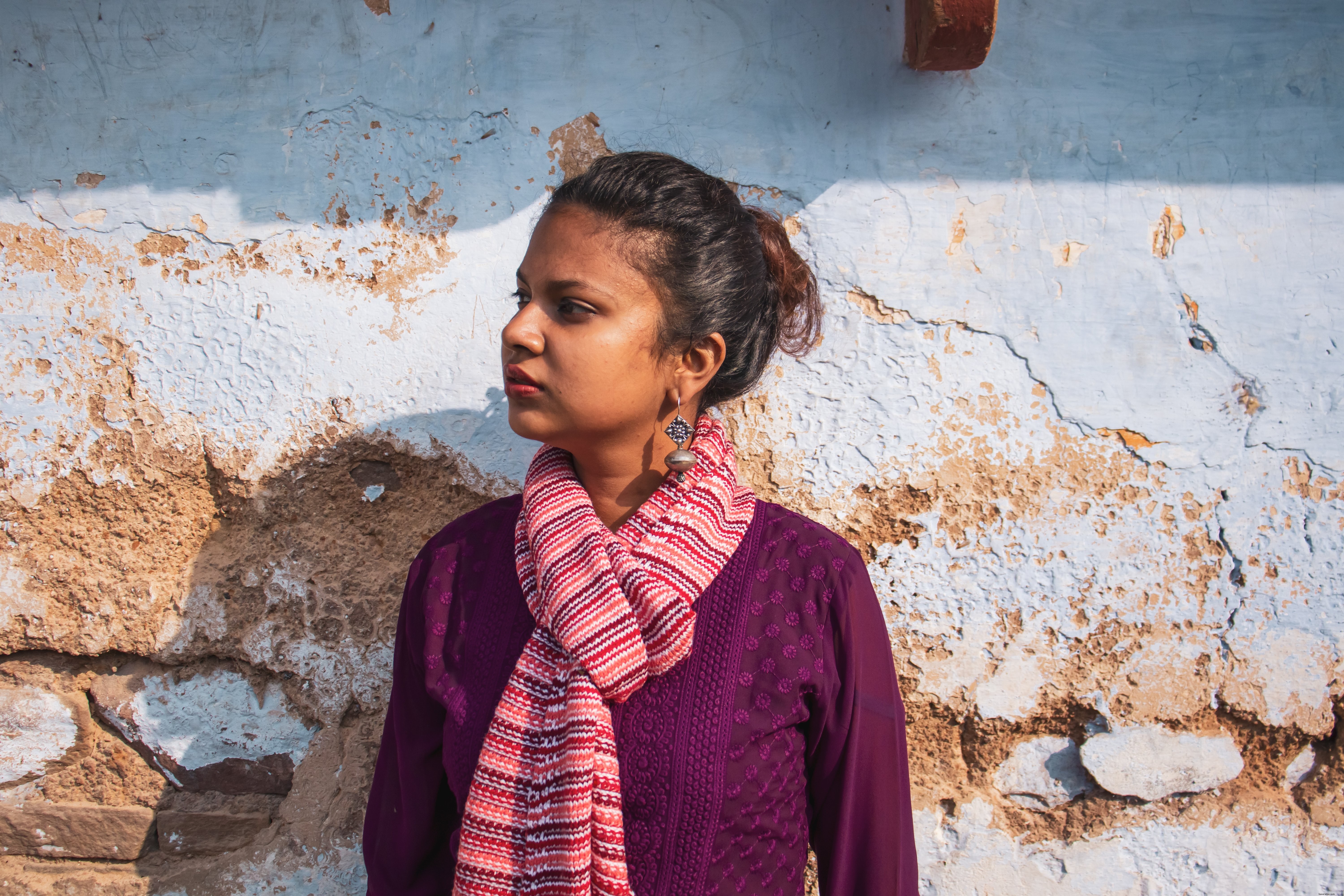 Portrait of a Person Standing Beside a White Cement Wall
