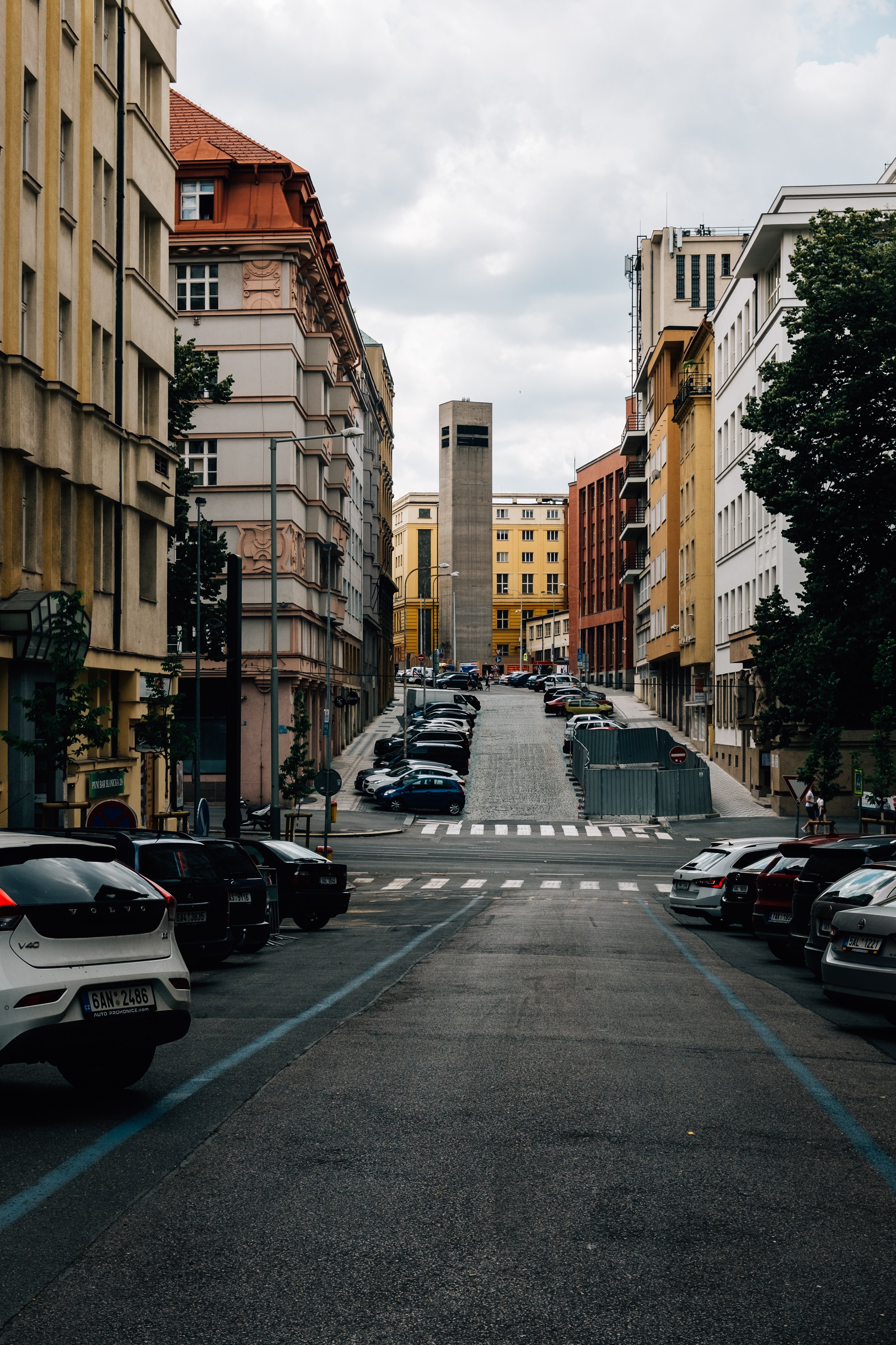 Colorful City Street Scene: Quiet Road, Vibrant Buildings & Parked Cars – Stunning Photo