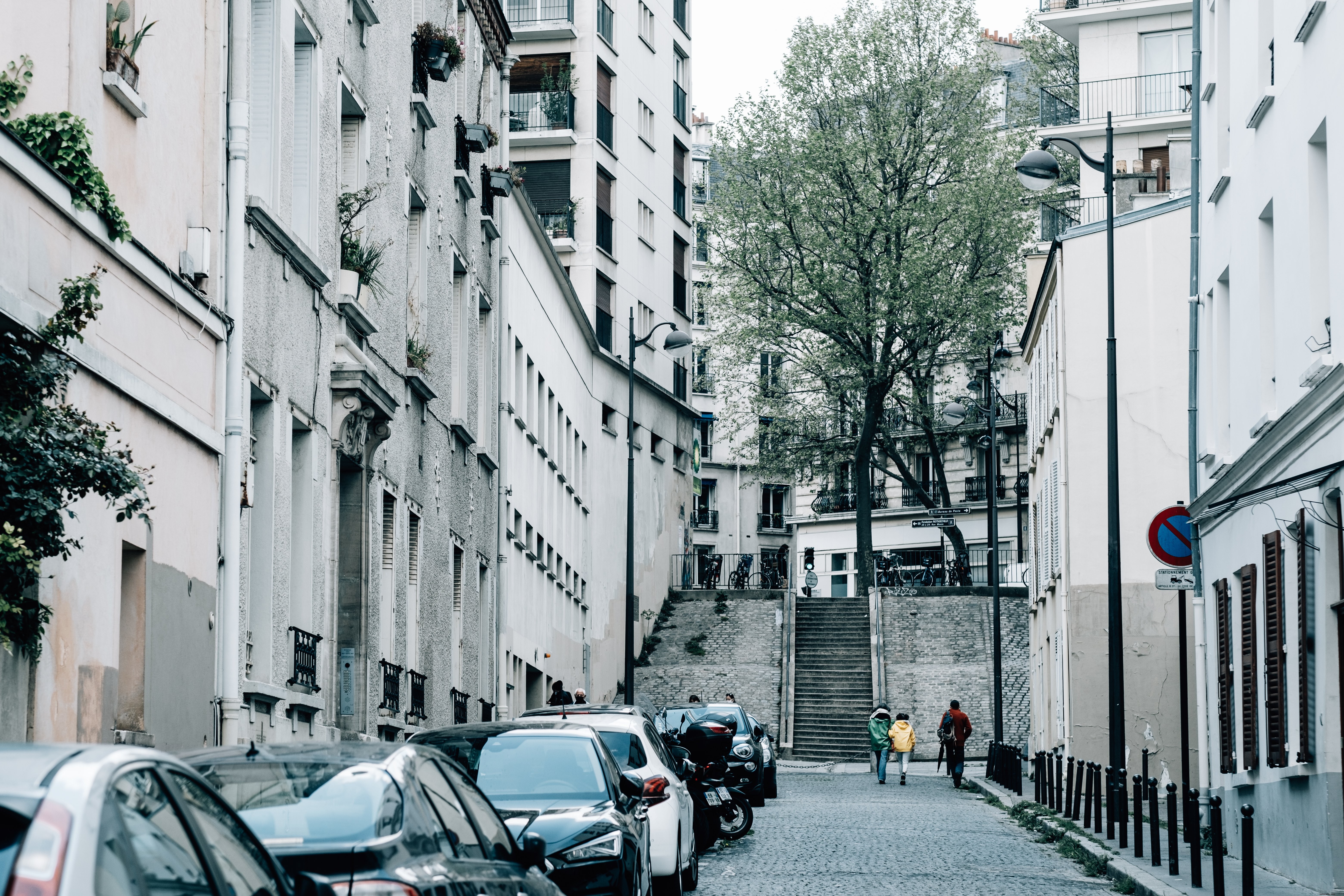 Vibrant Urban Scene: Cars on a City Street with Three Pedestrians – Captured in High-Resolution Photo