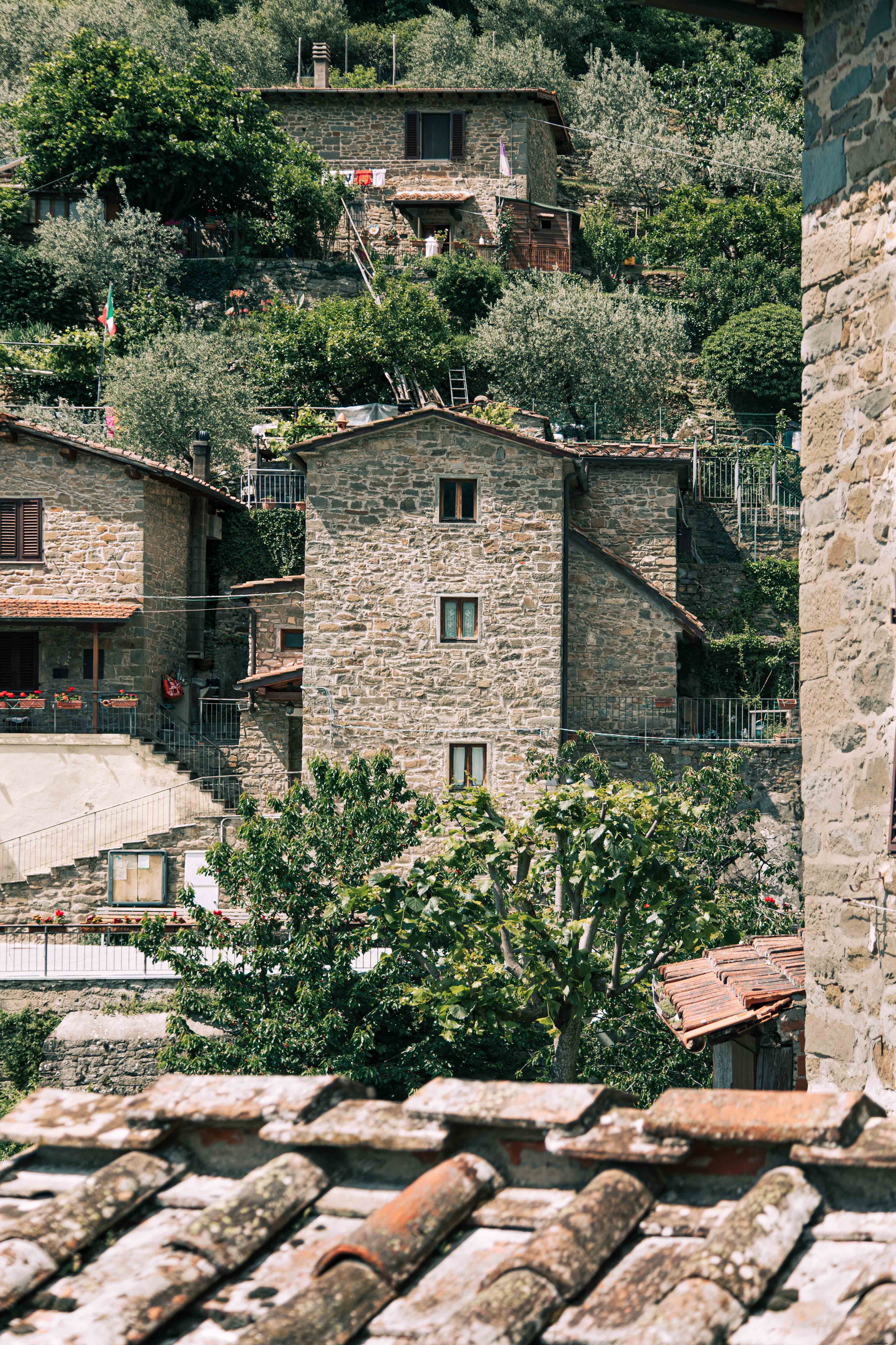 Stunning Hillside: Trees & Stone Buildings in a Breathtaking Photo