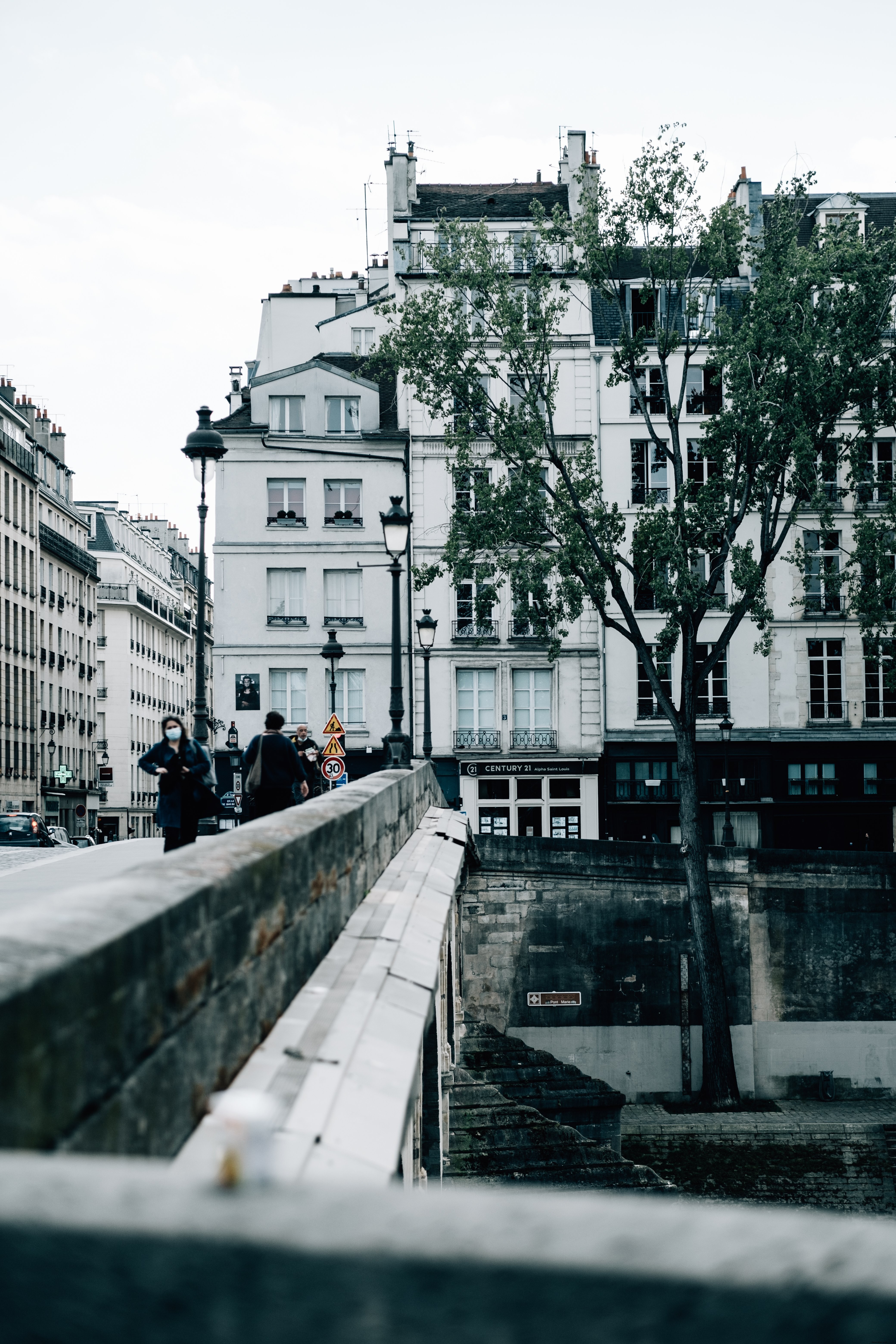 Strolling Across a Stone Bridge Amid Urban Architecture – A Captivating Photo