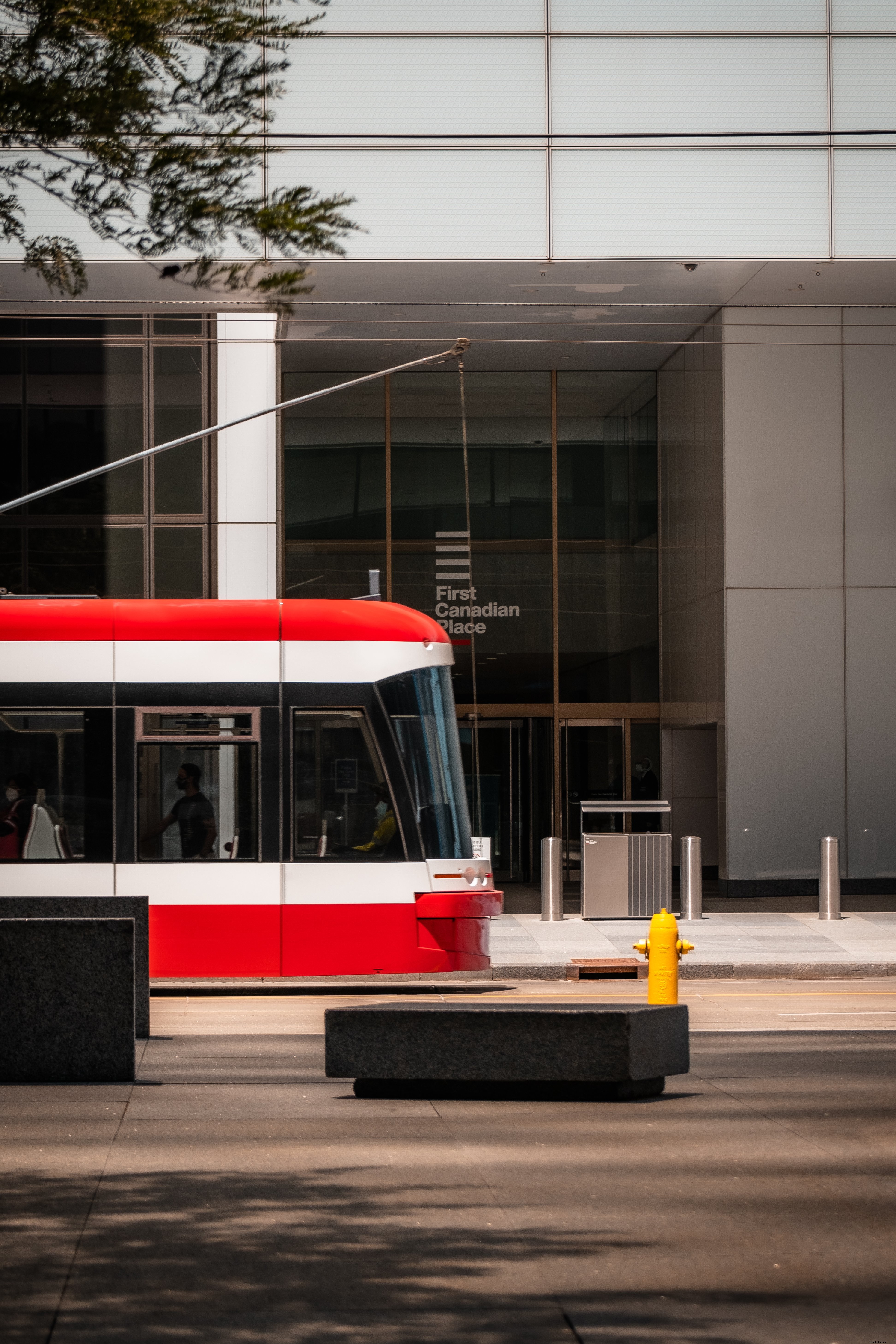 Red Streetcar Reflected in Glass Building: A Captivating Urban Moment