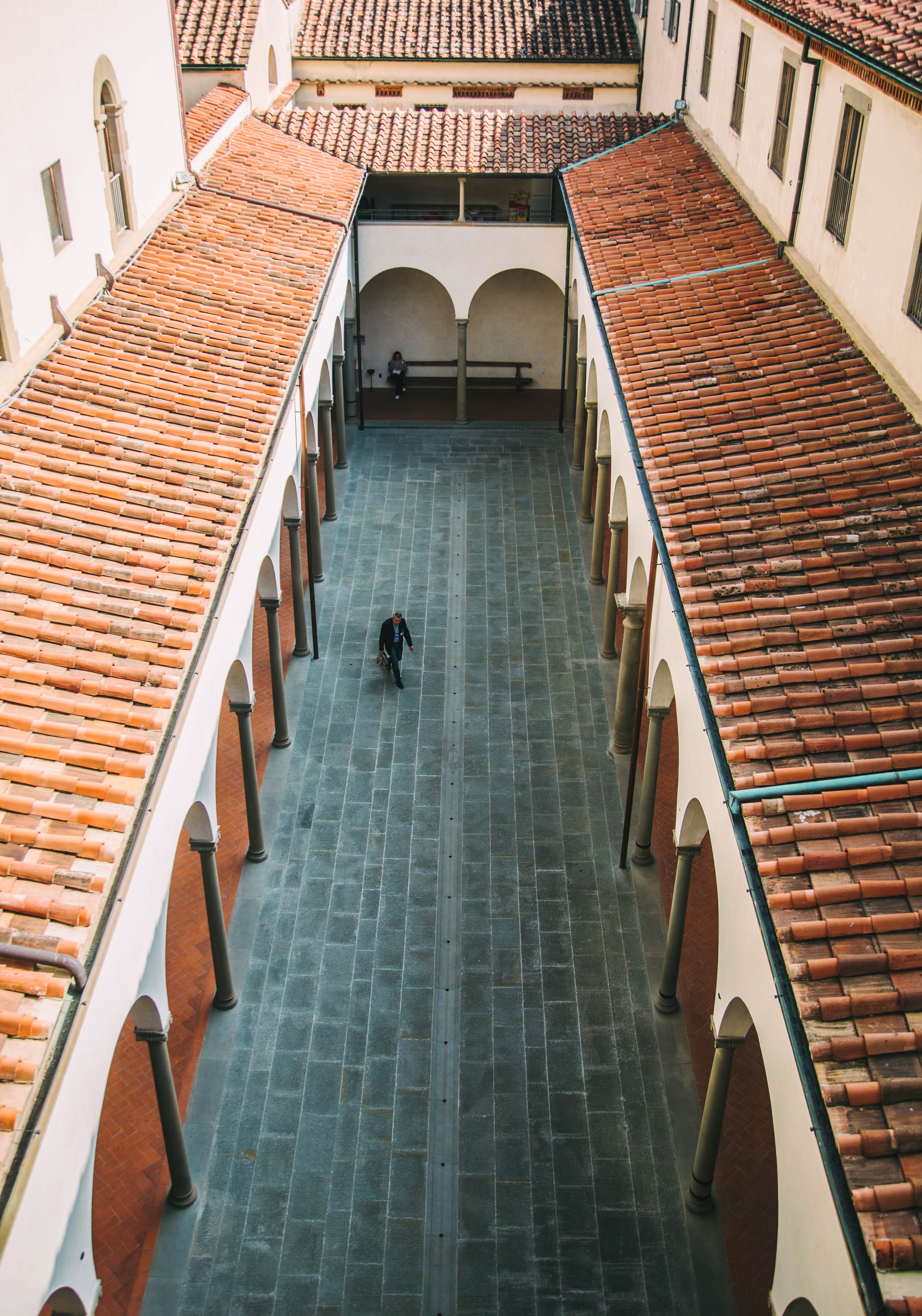 A Man Walks Through a Narrow Courtyard – A Captivating Urban Moment