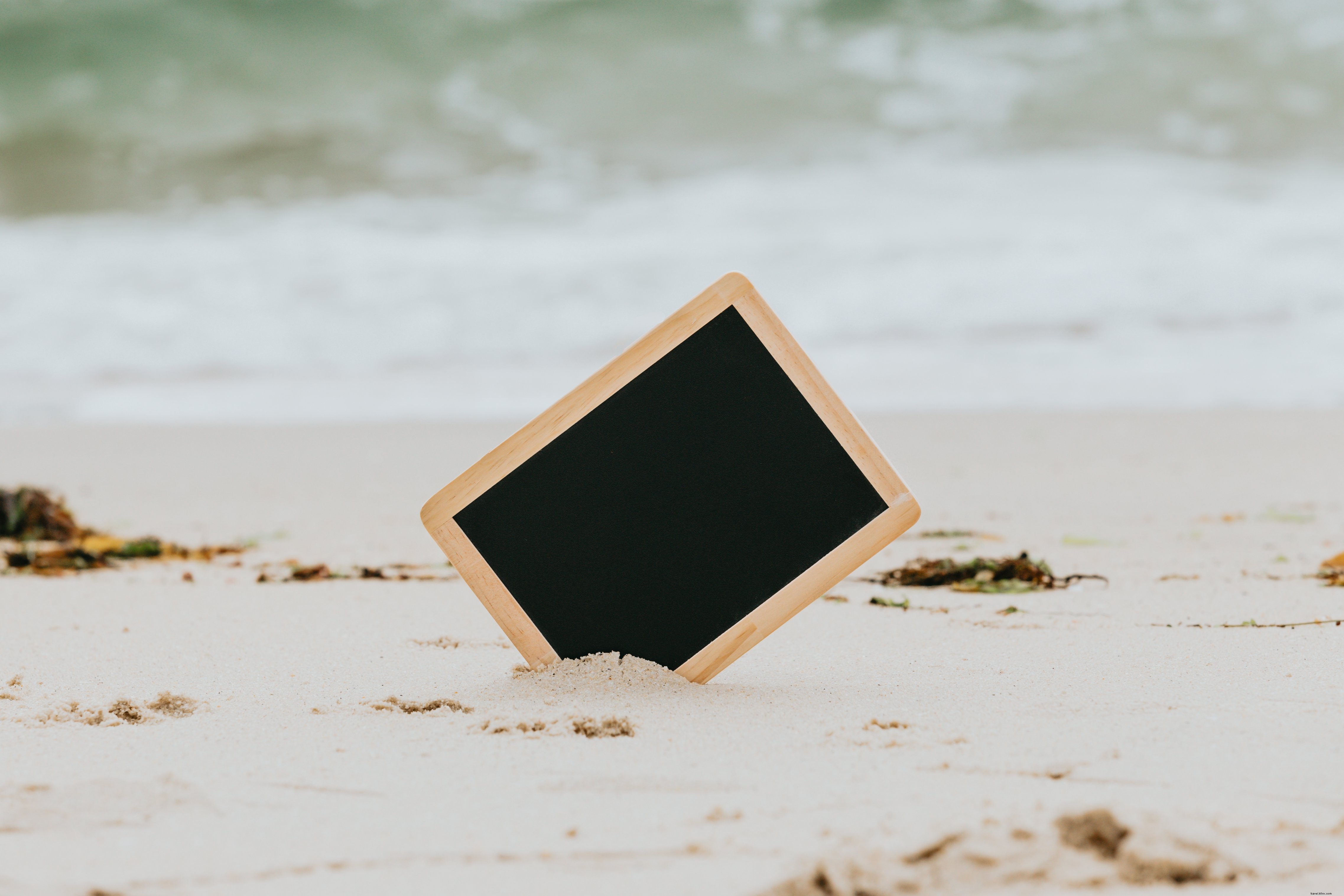 Black Chalkboard Stands Out on White Beach: A Captivating Visual