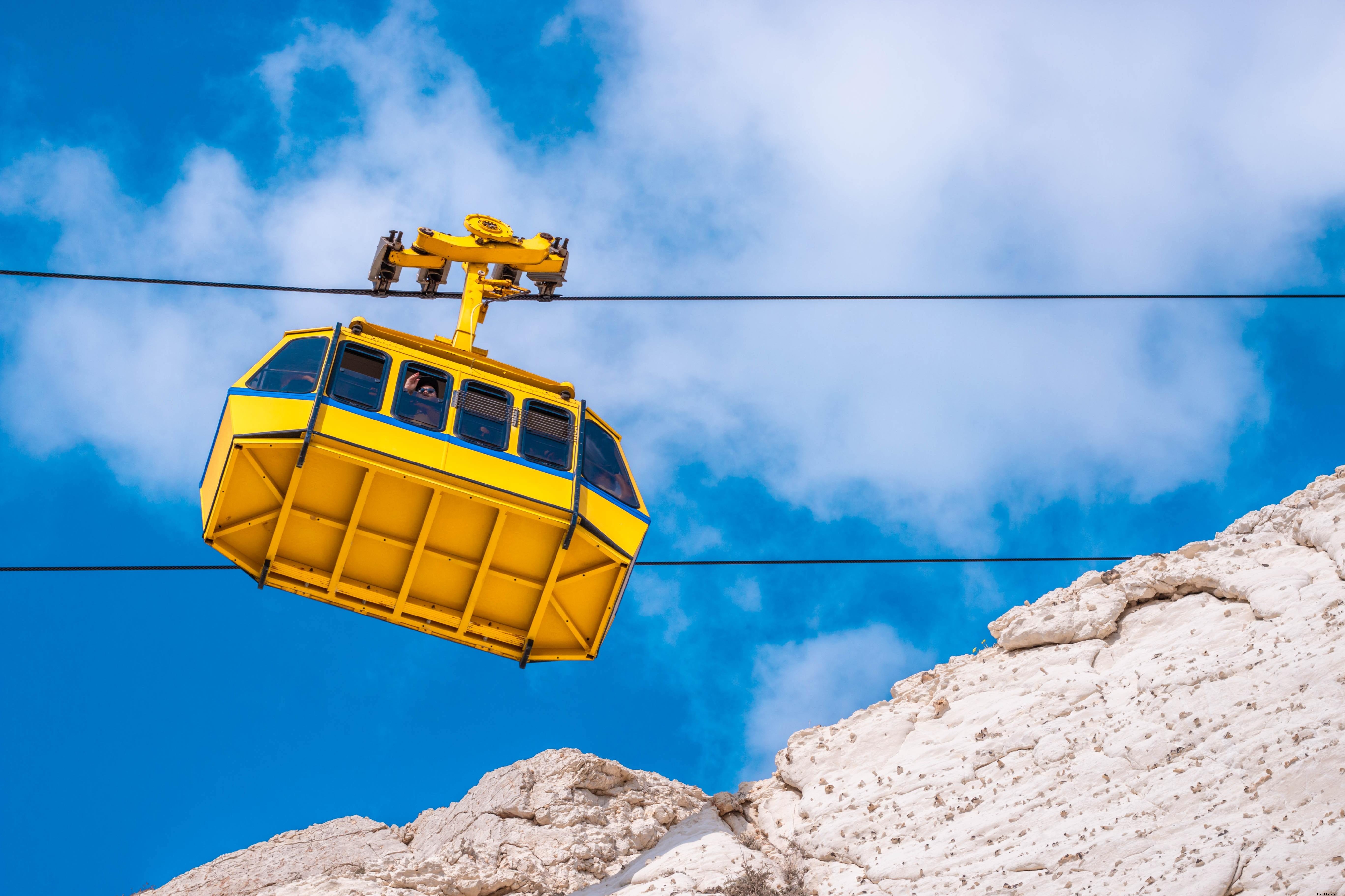 Stunning View of Yellow Cable Car Over White Rocky Mountains