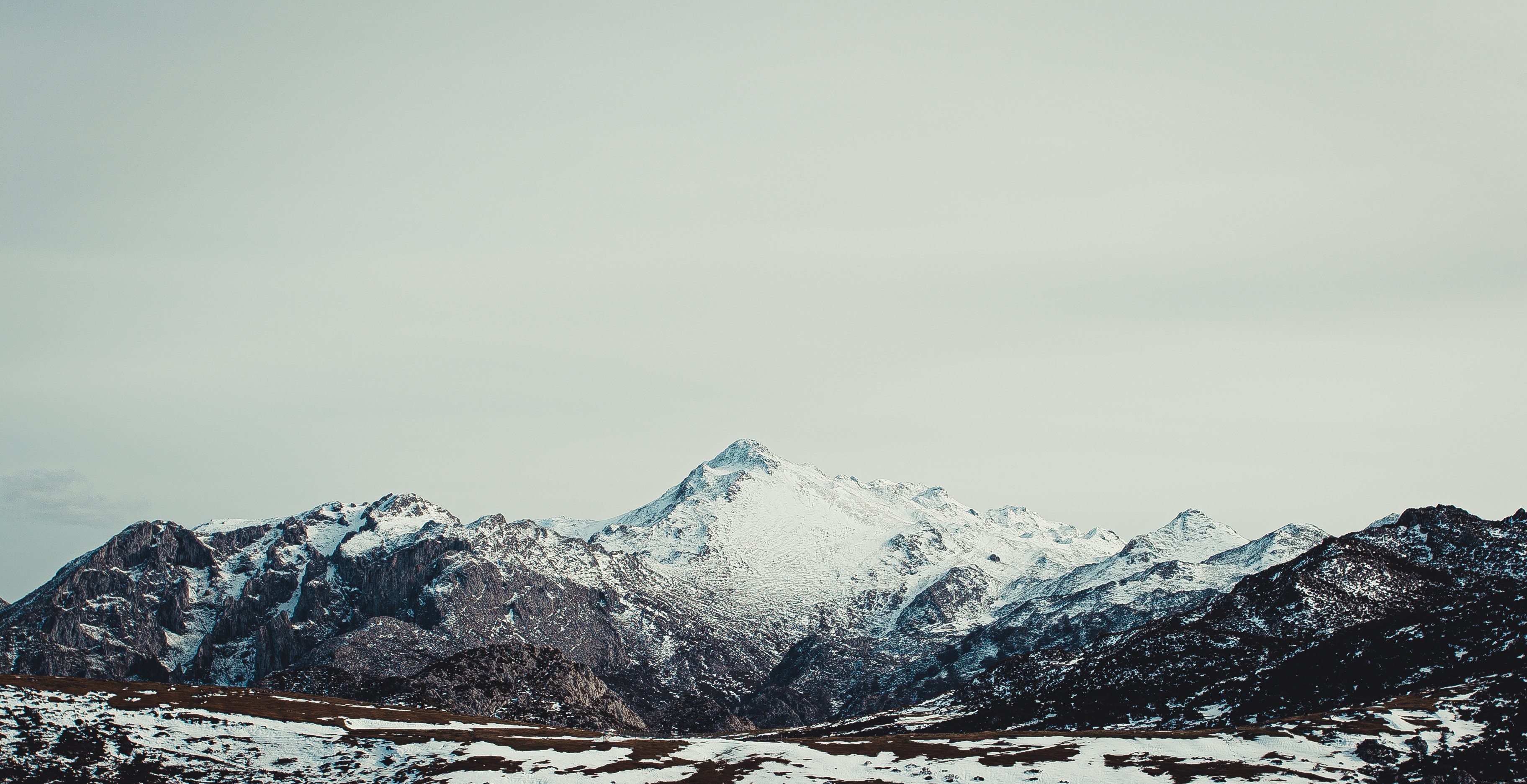 Majestic Snow‑Capped Mountain Under a Grey Sky