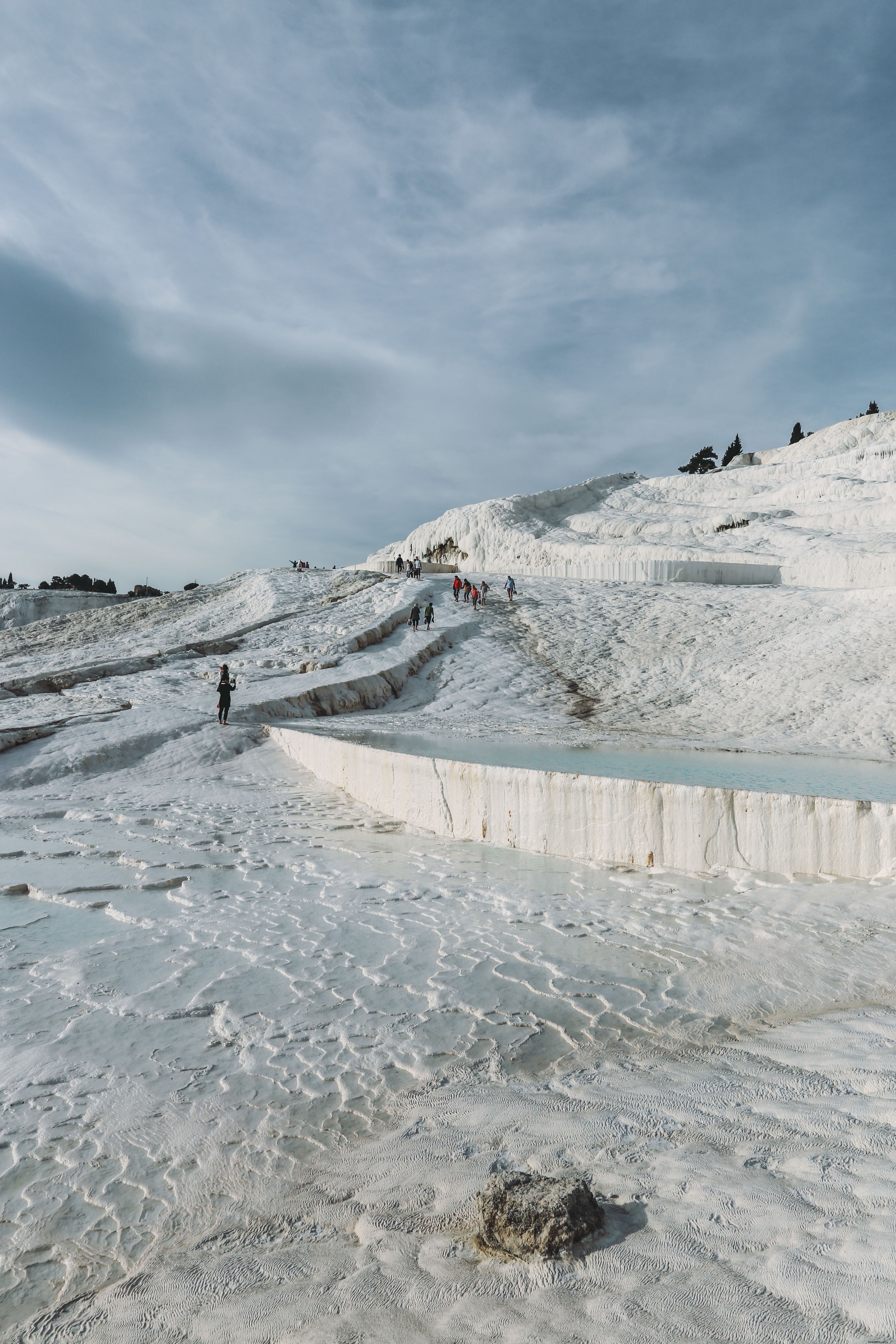 Eager Tourists Enjoy Thermal Pool Cascade – A Stunning Photo