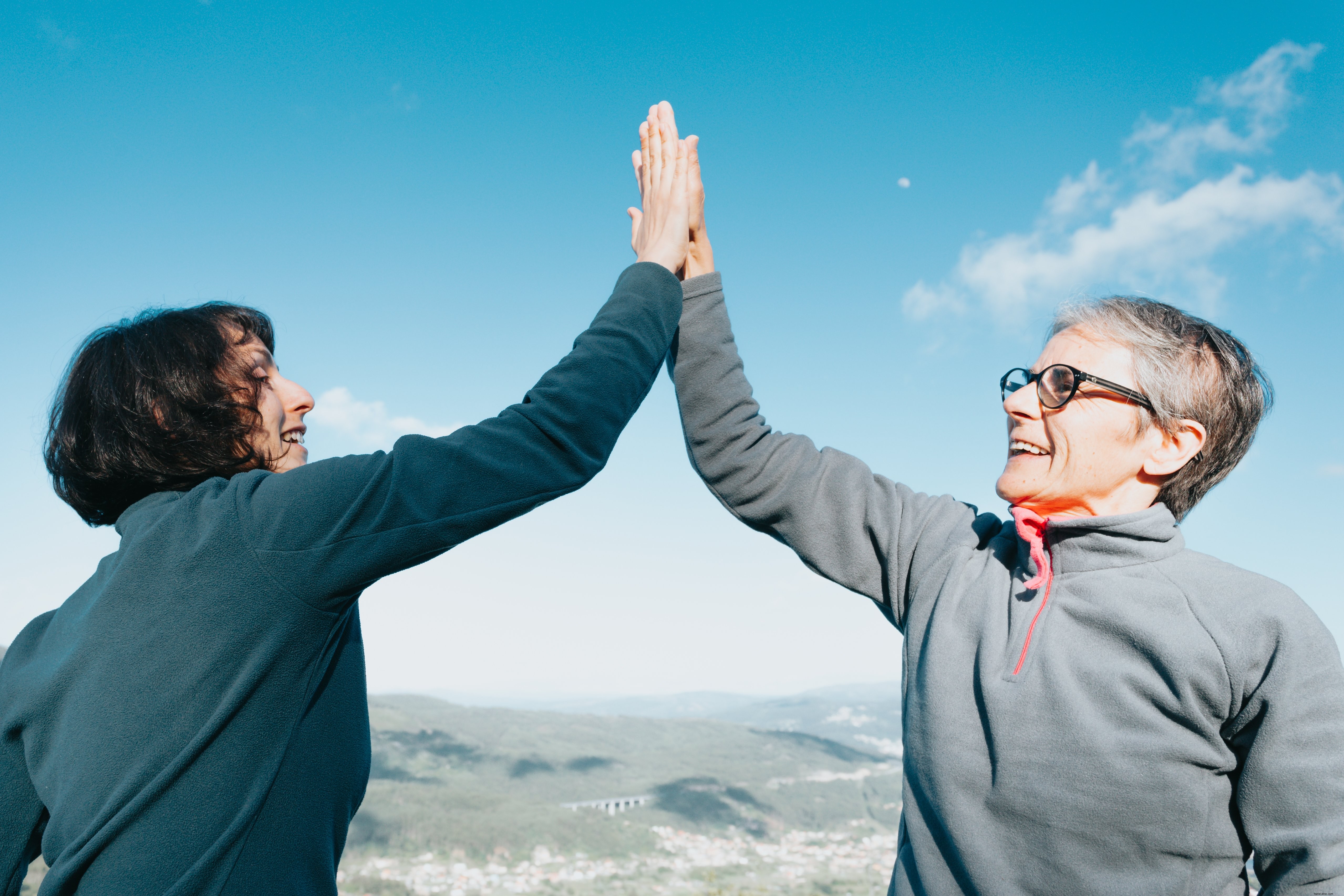 Celebrating Friendship: Two Women Share a High‑Five Beneath a Clear Blue Sky