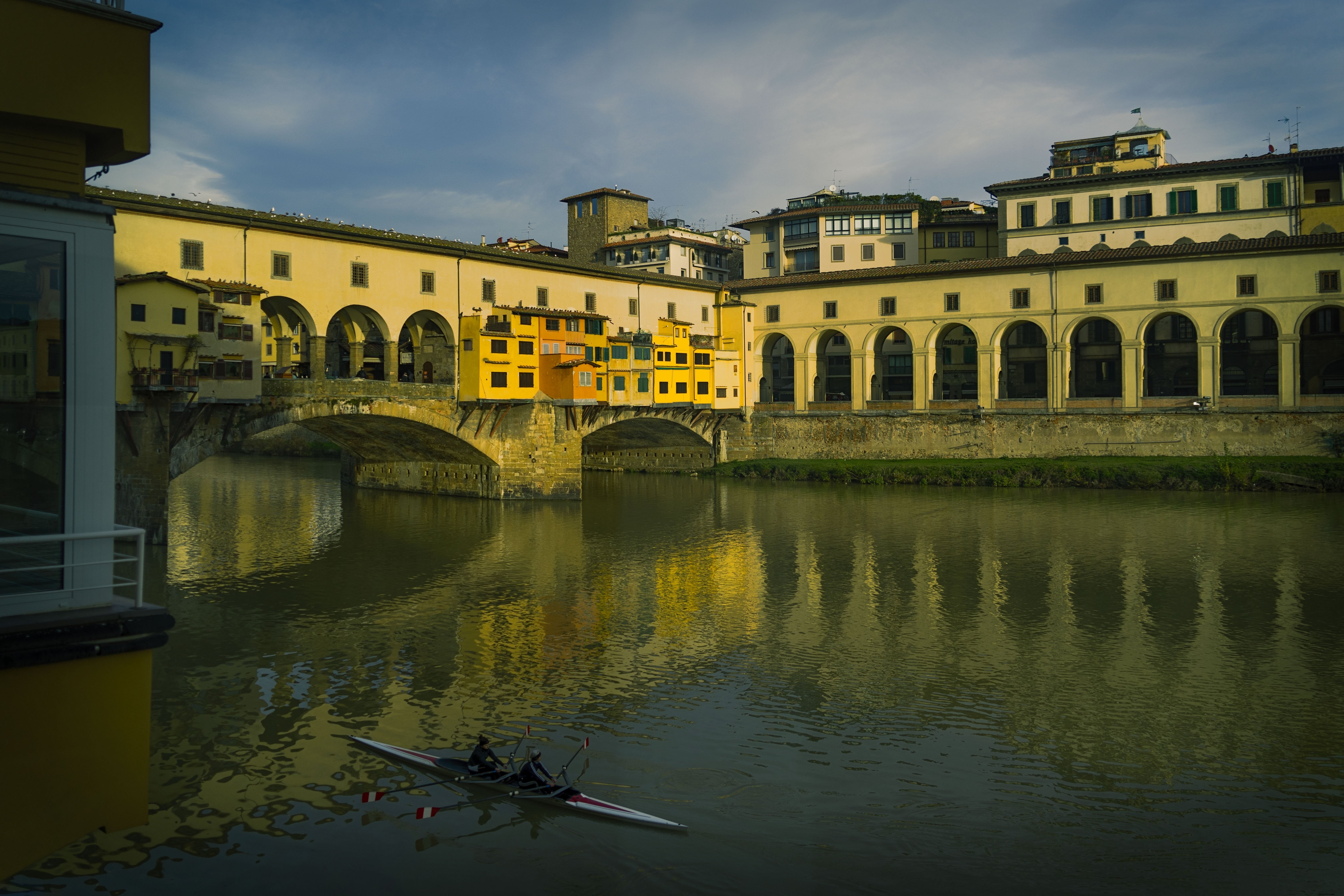 Stunning Riverside Bridge Amid Yellow Buildings – High-Resolution Photo