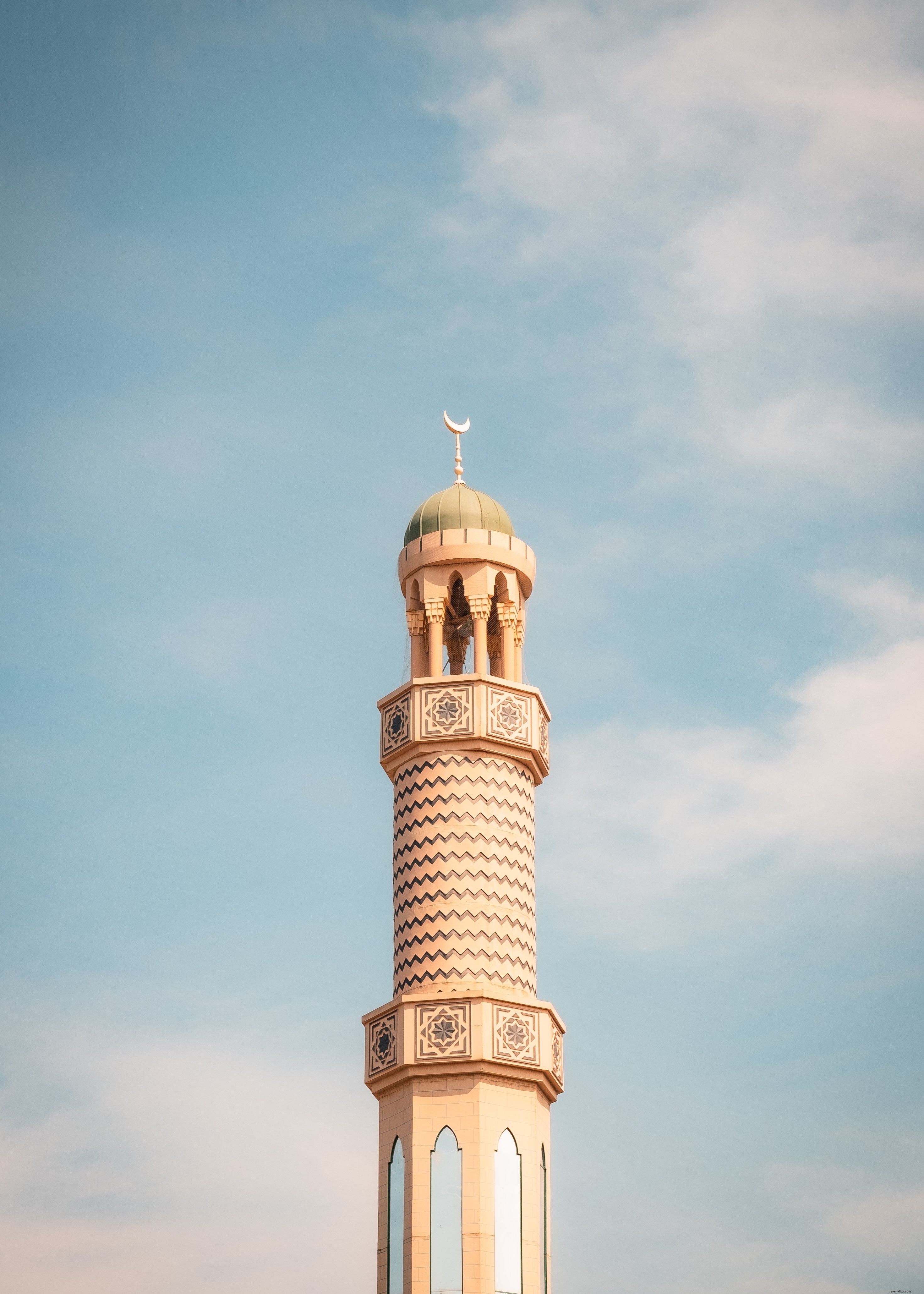 Stunning View of a Tall, Sleek Tower with a Round Roof Against a Clear Blue Sky